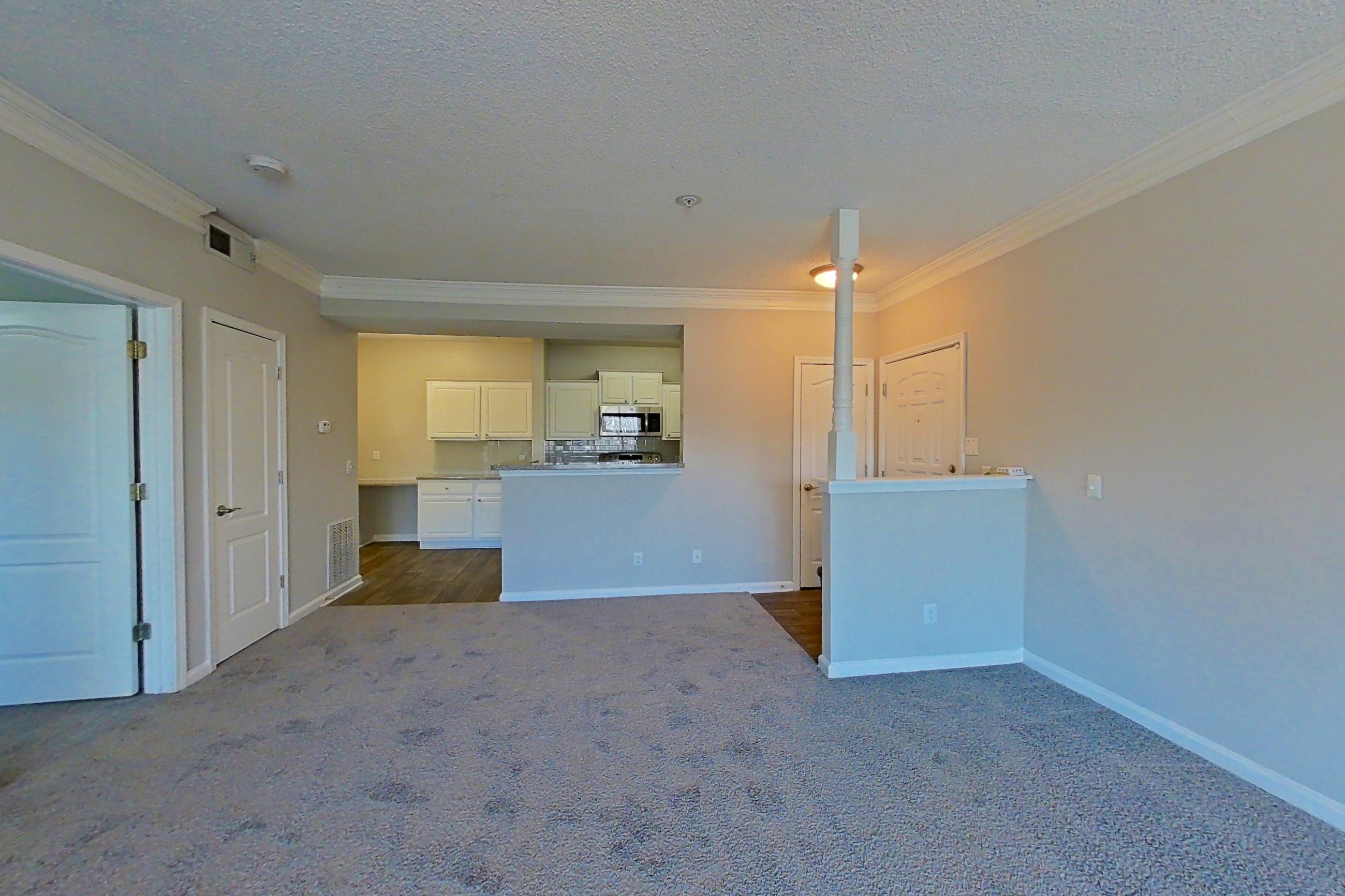 Living room with dark carpet, microwave, and stainless steel appliances, Apartment 124 at Marquis Midtown West