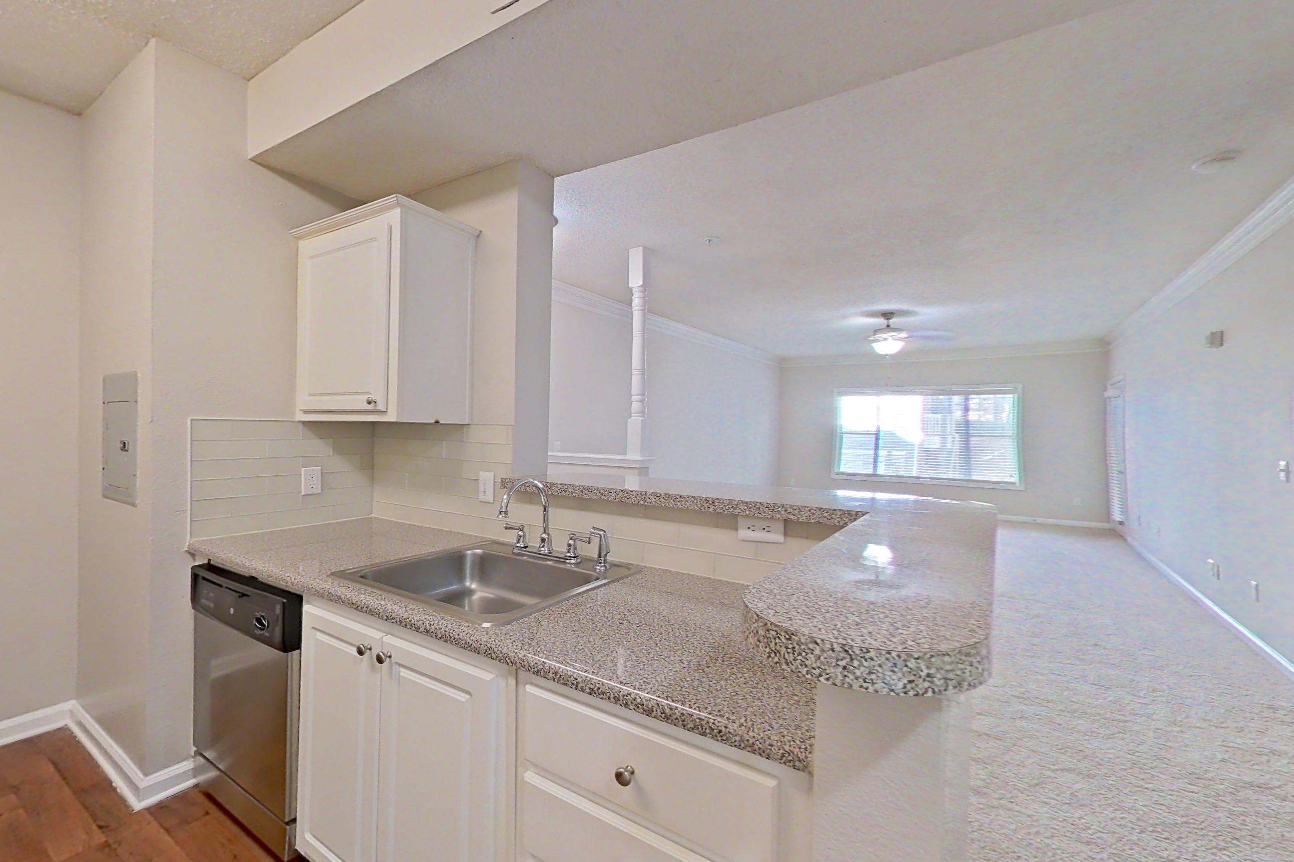 Kitchen with black appliances, dark wood-finish flooring, dishwasher, electric range, light countertops, light stone countertops, microwave, oven/range, refrigerator, and stainless steel appliances, Apartment 206 at Marquis Midtown West