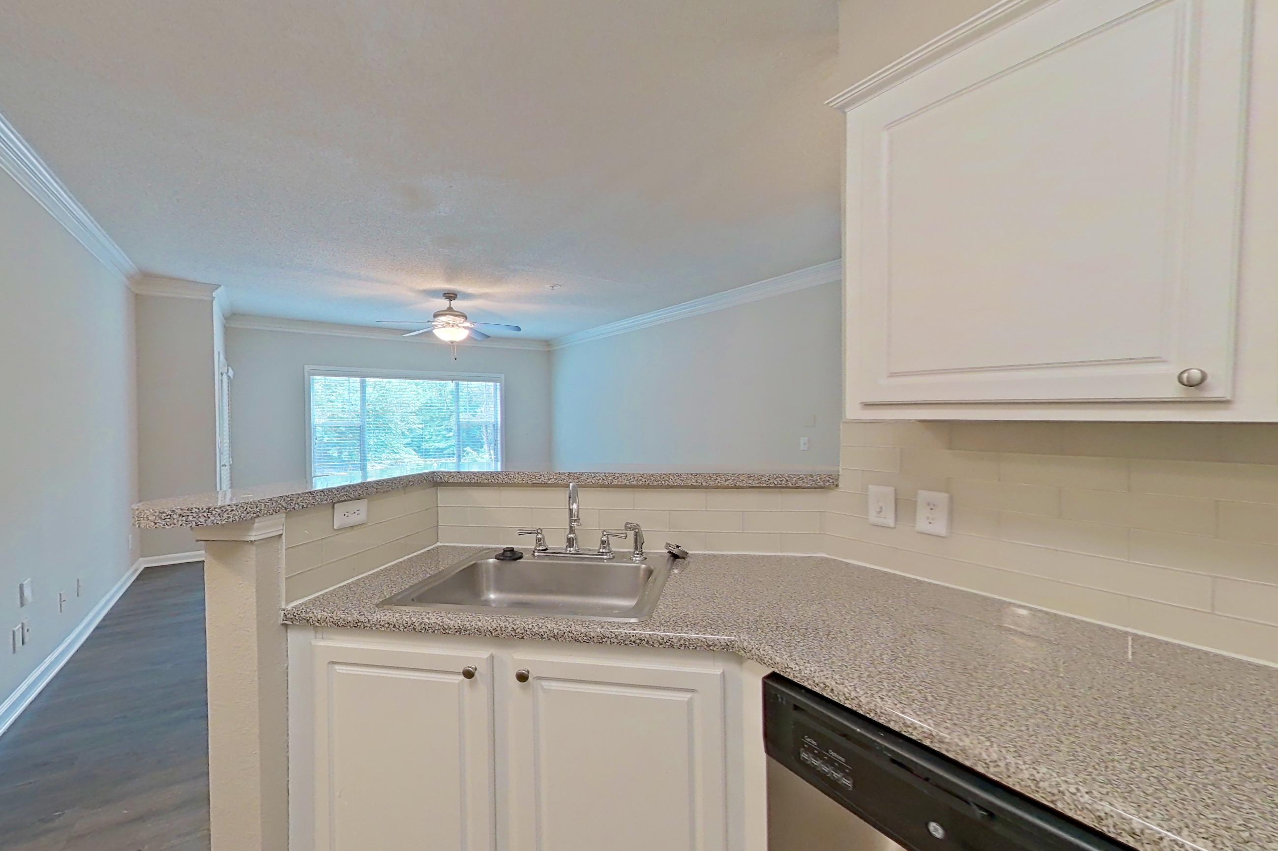 Kitchen with dark wood-finish flooring, dishwasher, electric range, light countertops, light stone countertops, microwave, oven/range, refrigerator, and stainless steel appliances, Apartment 434 at Marquis Midtown West
