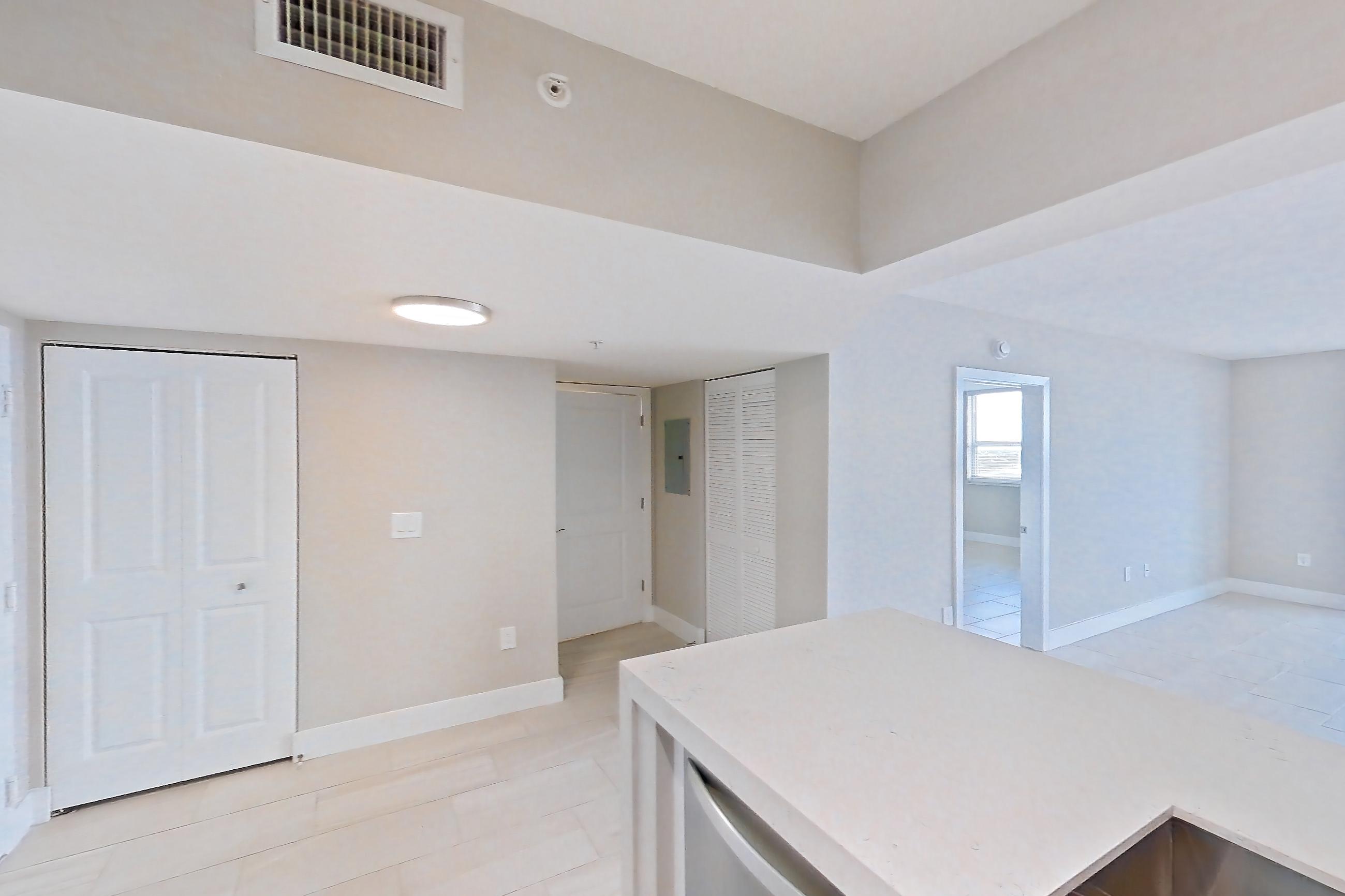 Kitchen with dishwasher, electric range, light countertops, light stone countertops, oven/range, refrigerator, and stainless steel appliances, Apartment 0952 at Sunrise Harbor