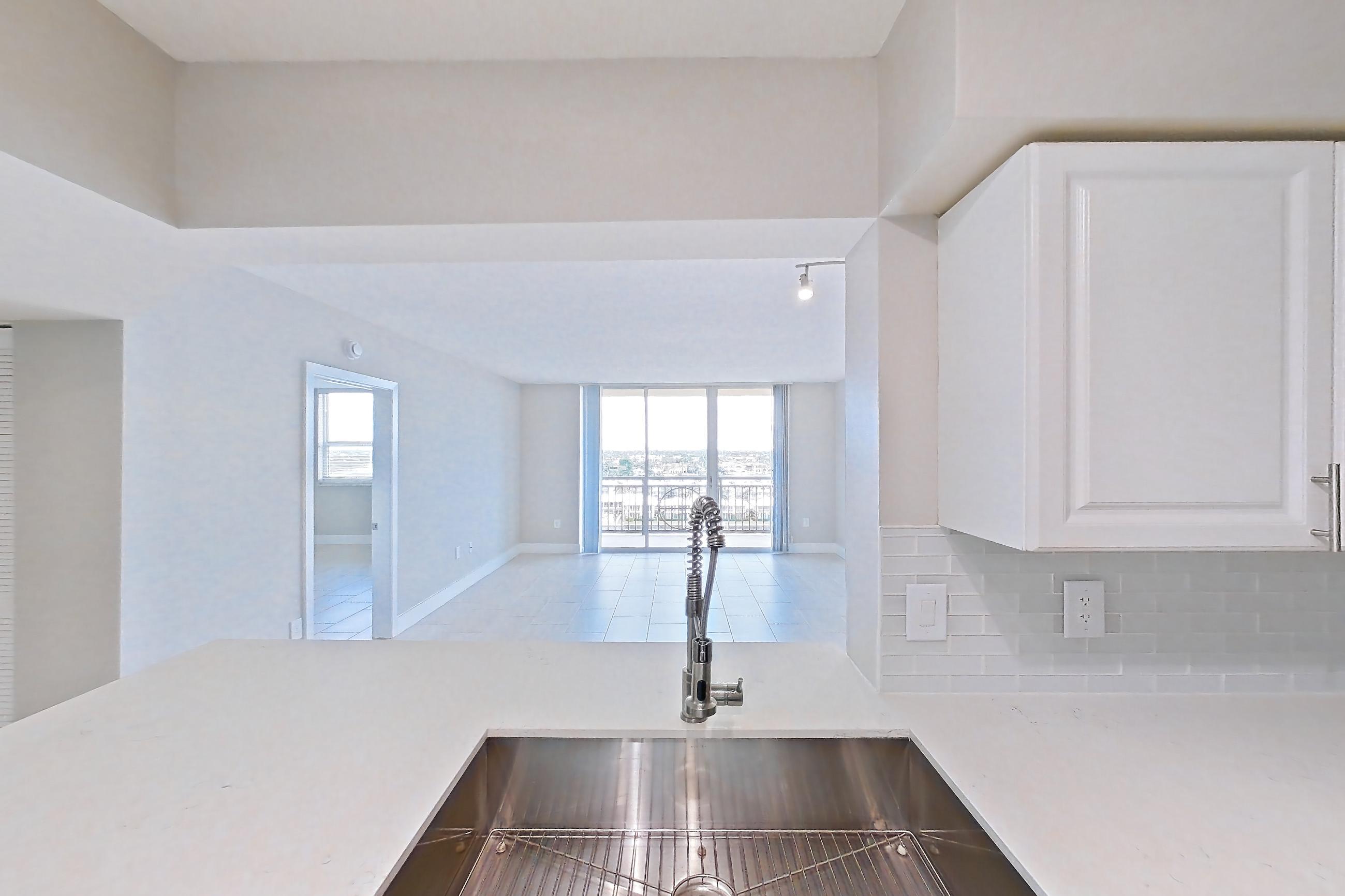 Kitchen with dishwasher, electric range, light countertops, light stone countertops, oven/range, refrigerator, and stainless steel appliances, Apartment 0952 at Sunrise Harbor