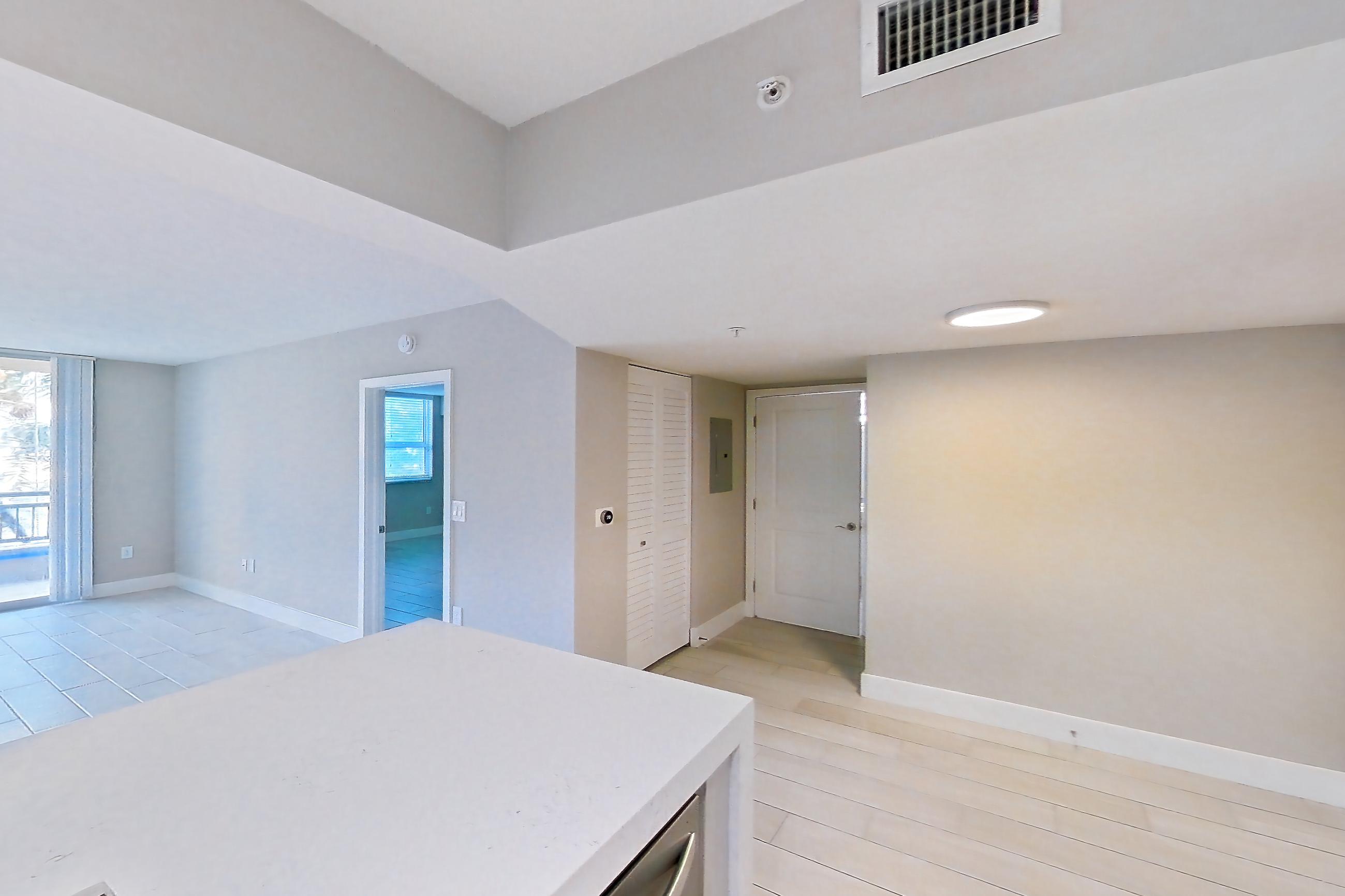 Kitchen with dishwasher, electric range, light countertops, light stone countertops, light tile flooring, light wood-finish flooring, oven/range, refrigerator, stainless steel appliances, and wood-look tile flooring, Apartment 0210 at Sunrise Harbor