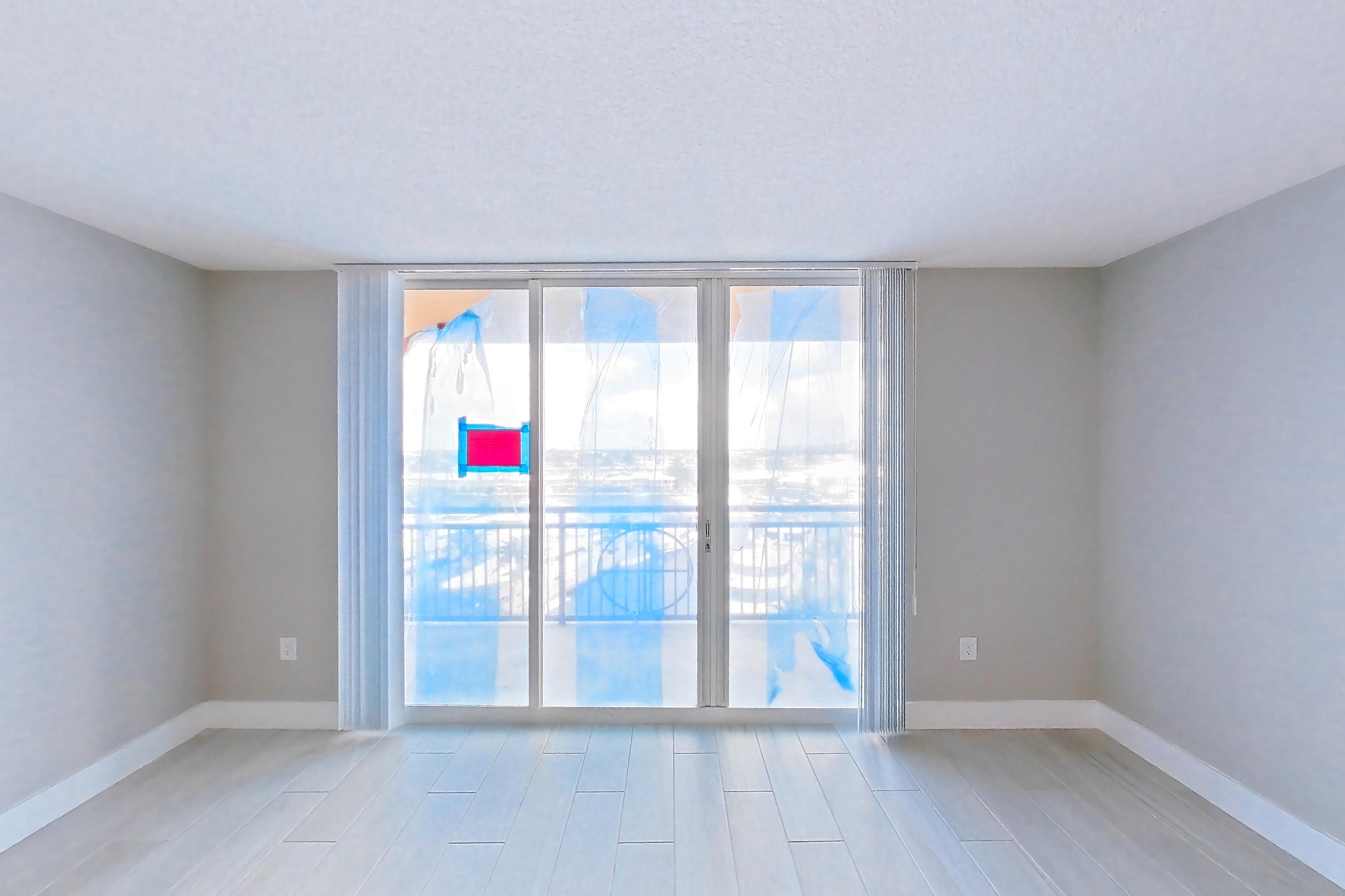 Living room with light wood-finish flooring and wood-look tile flooring, Apartment 0709 at Sunrise Harbor