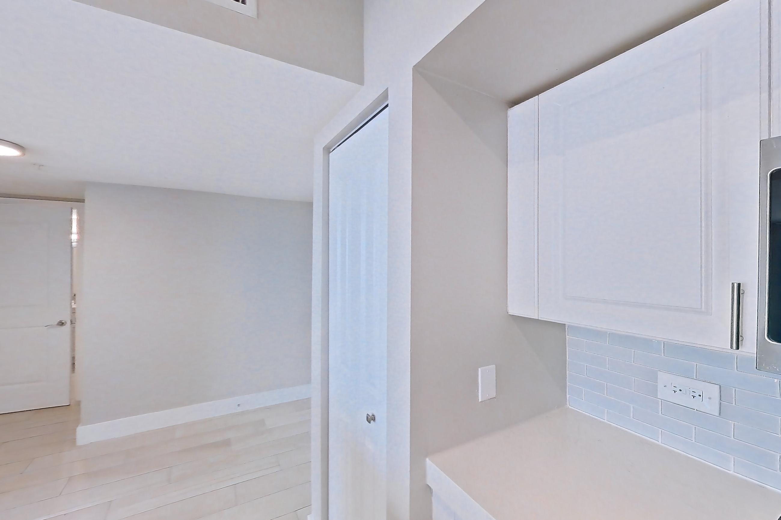 Kitchen with dishwasher, light countertops, light stone countertops, light tile flooring, light wood-finish flooring, oven/range, refrigerator, stainless steel appliances, and wood-look tile flooring, Apartment 1706 at Sunrise Harbor