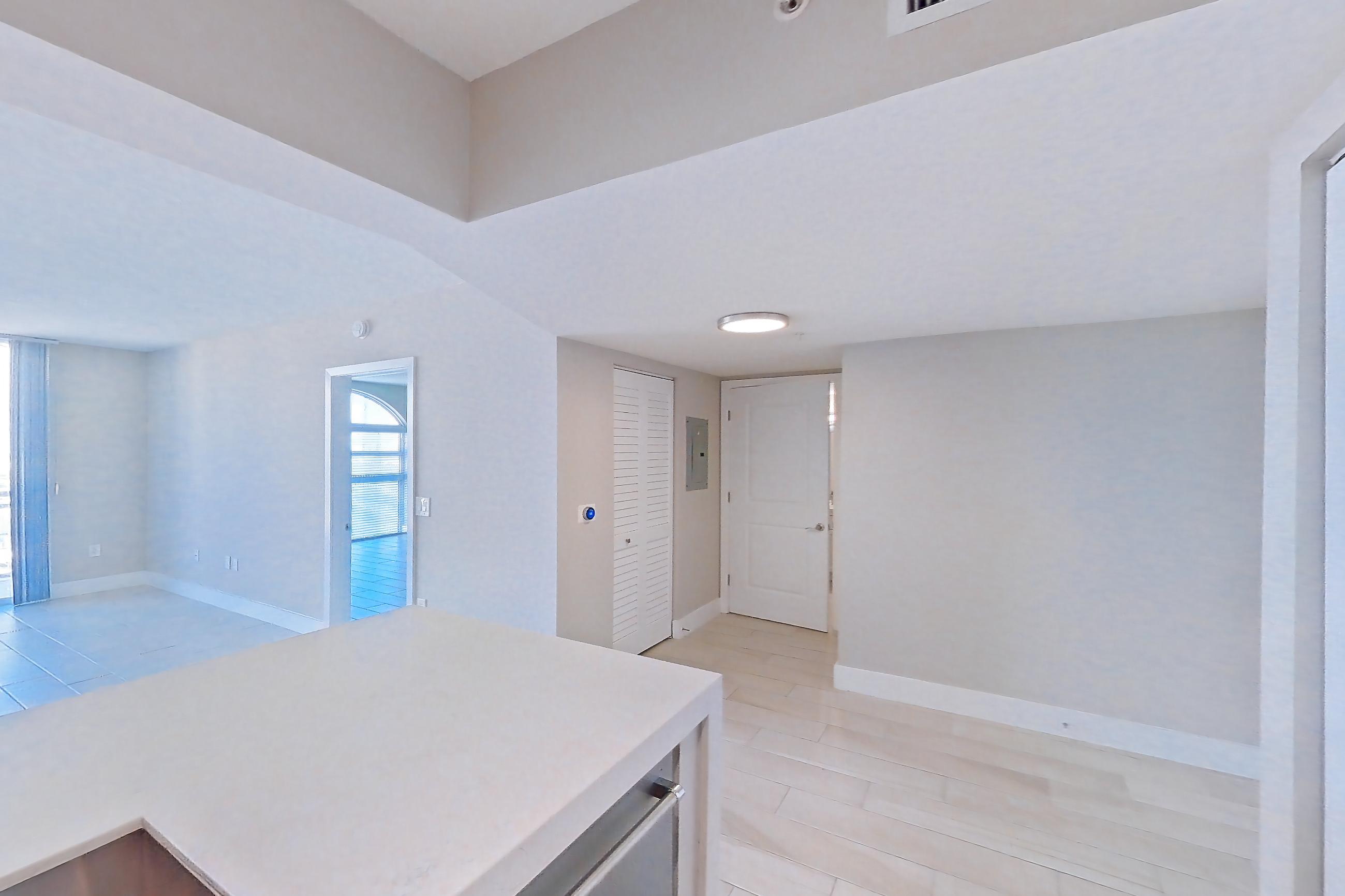 Kitchen with dishwasher, light countertops, light stone countertops, light tile flooring, light wood-finish flooring, oven/range, refrigerator, stainless steel appliances, and wood-look tile flooring, Apartment 1706 at Sunrise Harbor