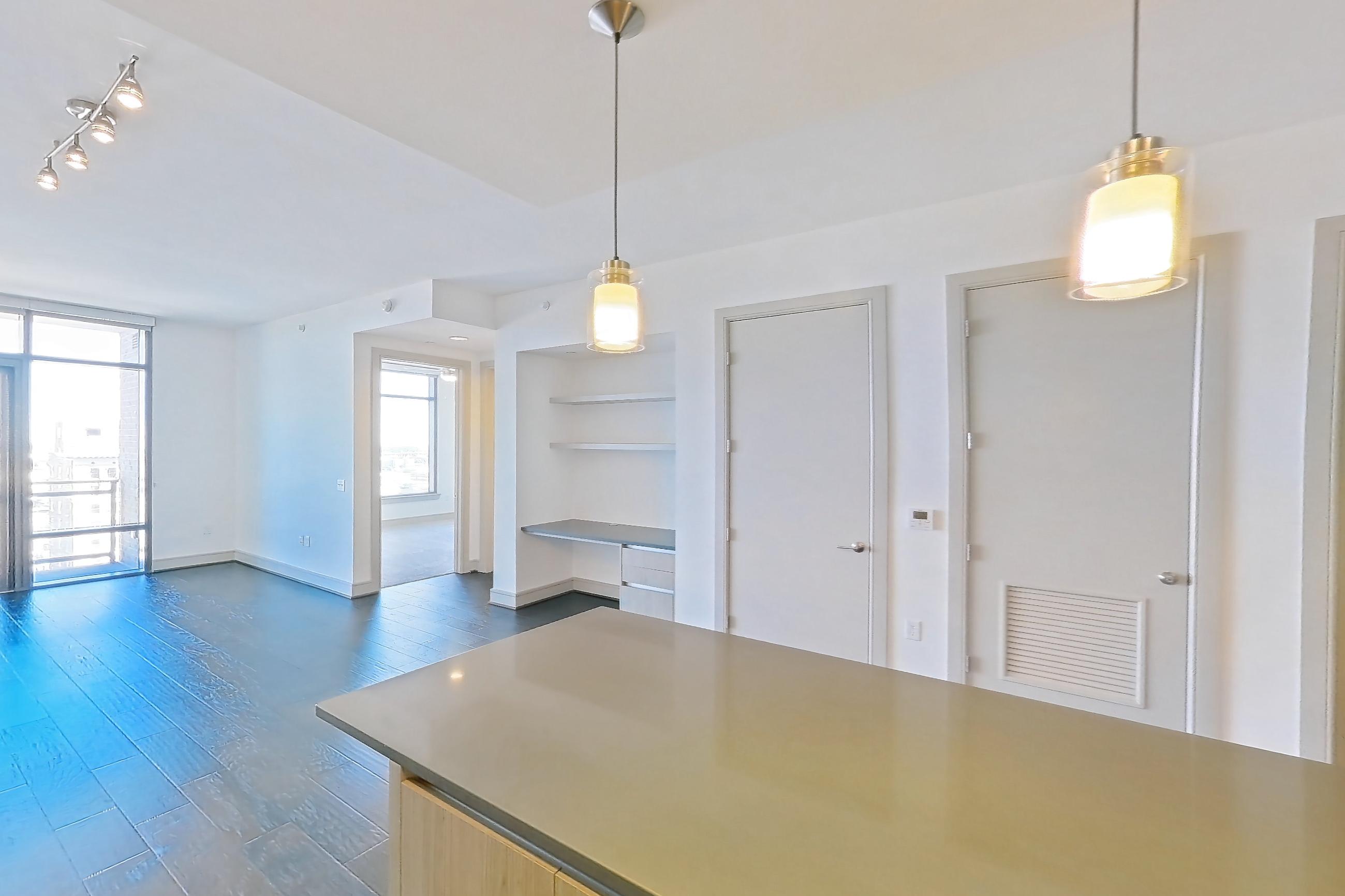 Kitchen with dark wood-finish flooring, dishwasher, gas range, light countertops, oven/range, stainless steel appliances, and wood-finish flooring, Apartment 1608 at Aris Market Square