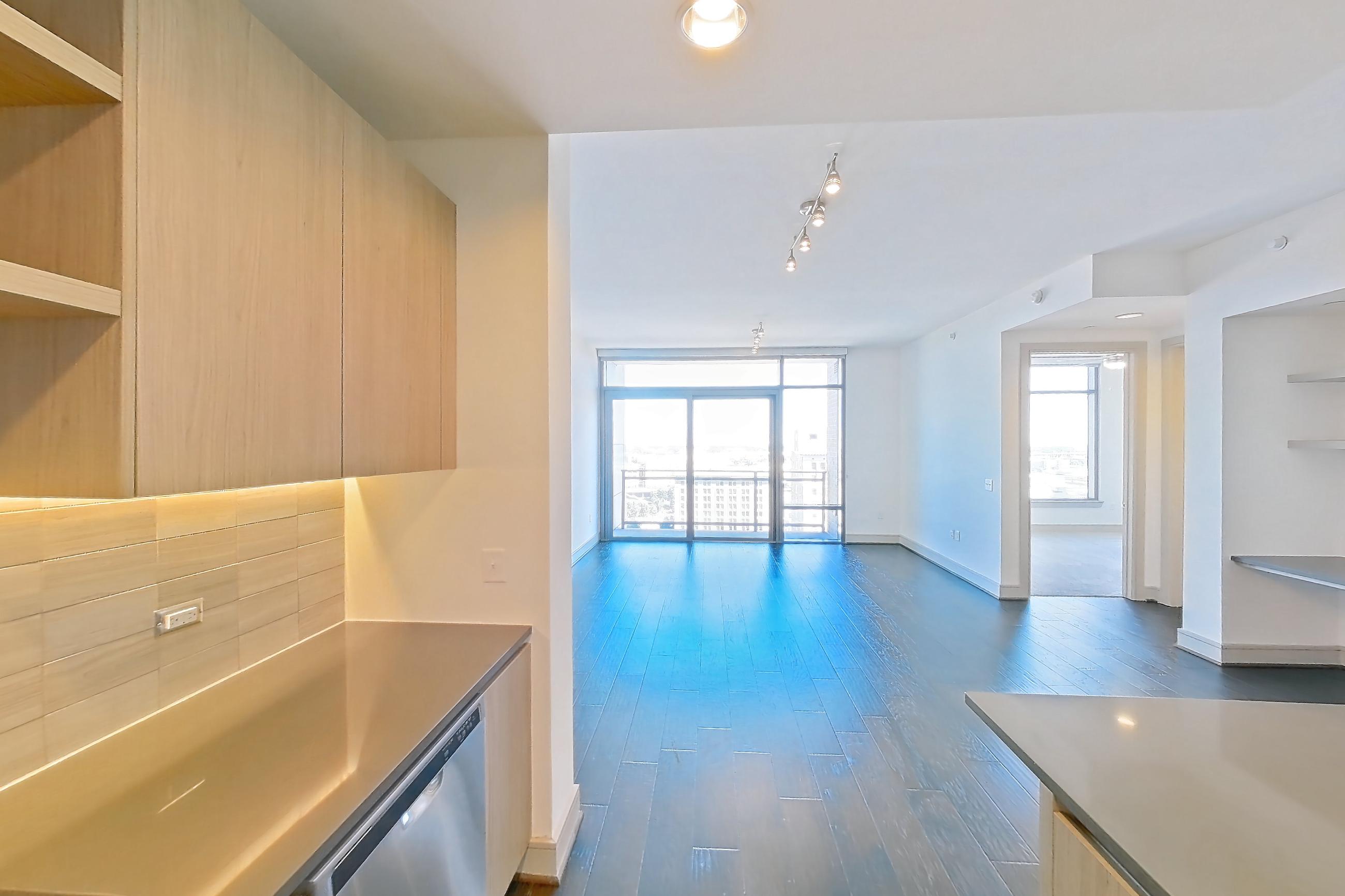 Kitchen with dark wood-finish flooring, dishwasher, gas range, light countertops, oven/range, stainless steel appliances, and wood-finish flooring, Apartment 1608 at Aris Market Square