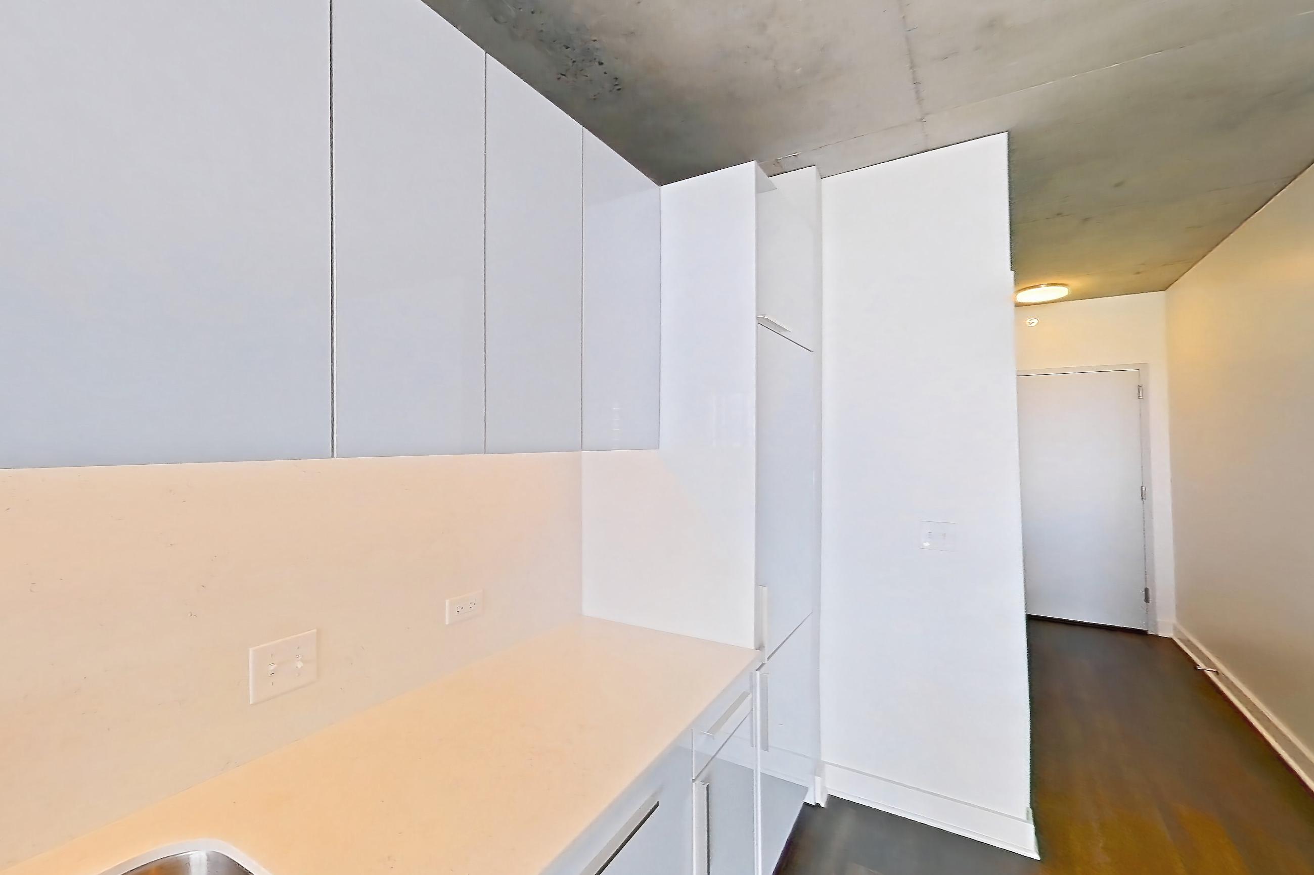 Kitchen with black appliances, cooktop, dark wood-finish flooring, electric cooktop, and light stone countertops, Apartment 2103 at 220 WIL
