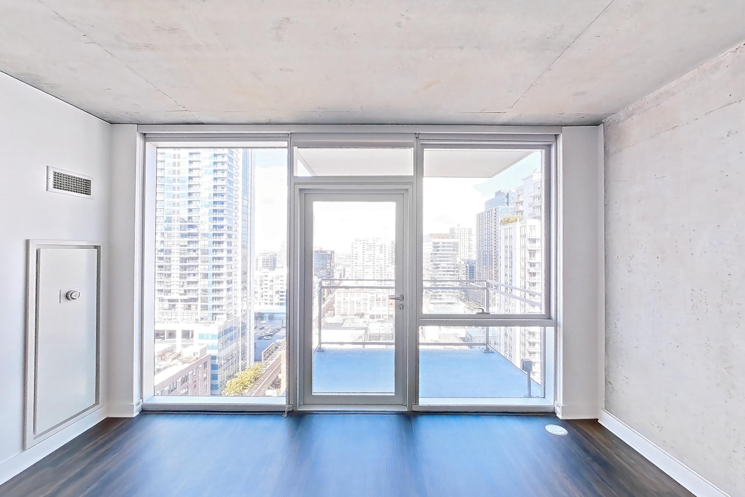 Living room with city view and dark wood-finish flooring, Apartment 2103 at 220 WIL