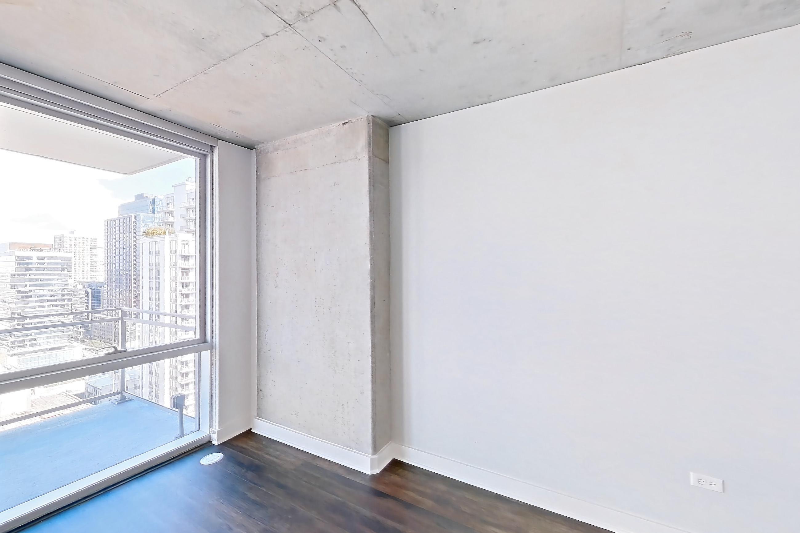 Living room with city view and dark wood-finish flooring, Apartment 2103 at 220 WIL