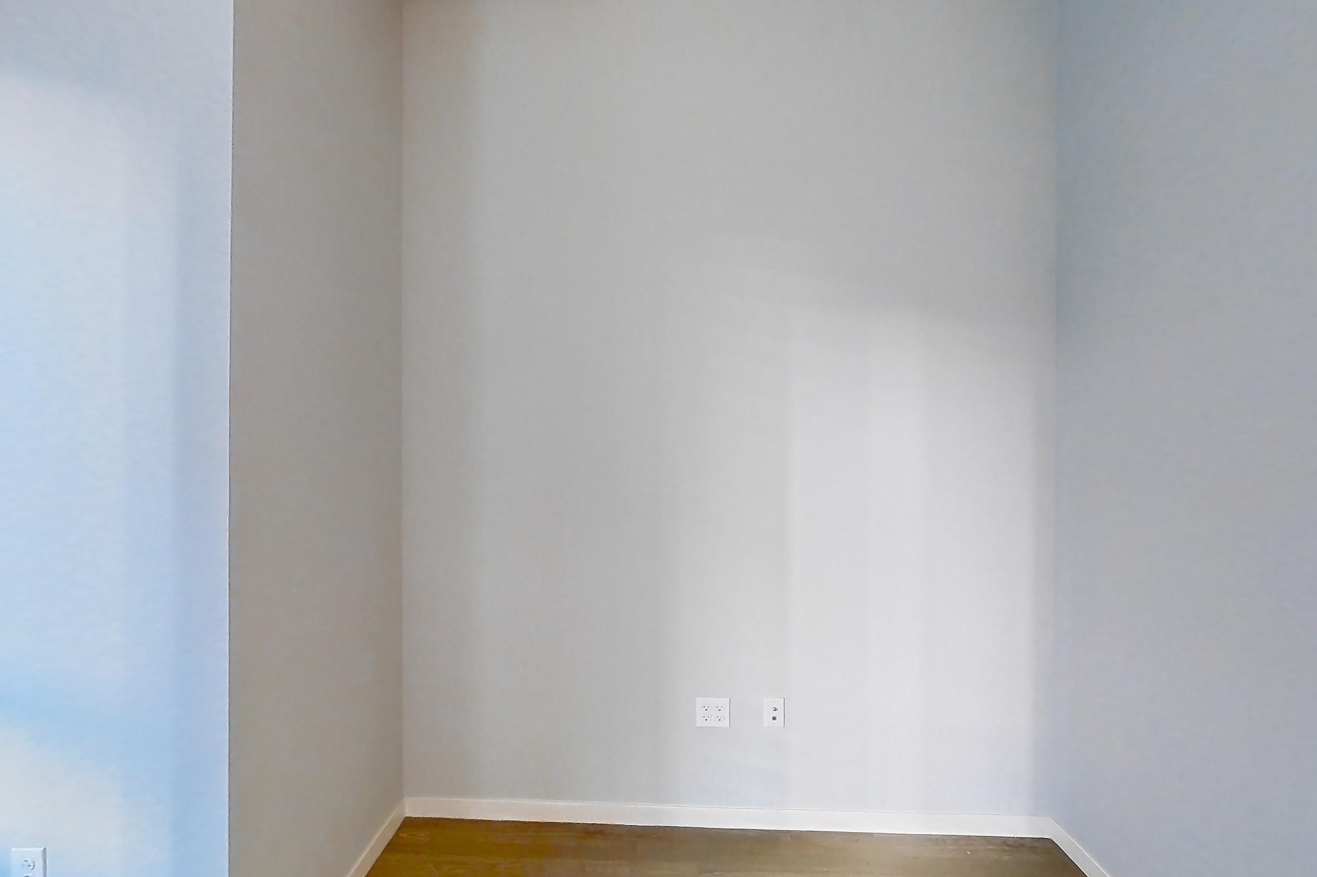 Living room with dark wood-finish flooring, light wood-finish flooring, and refrigerator, Apartment 1-0310 at Cortland Rosslyn