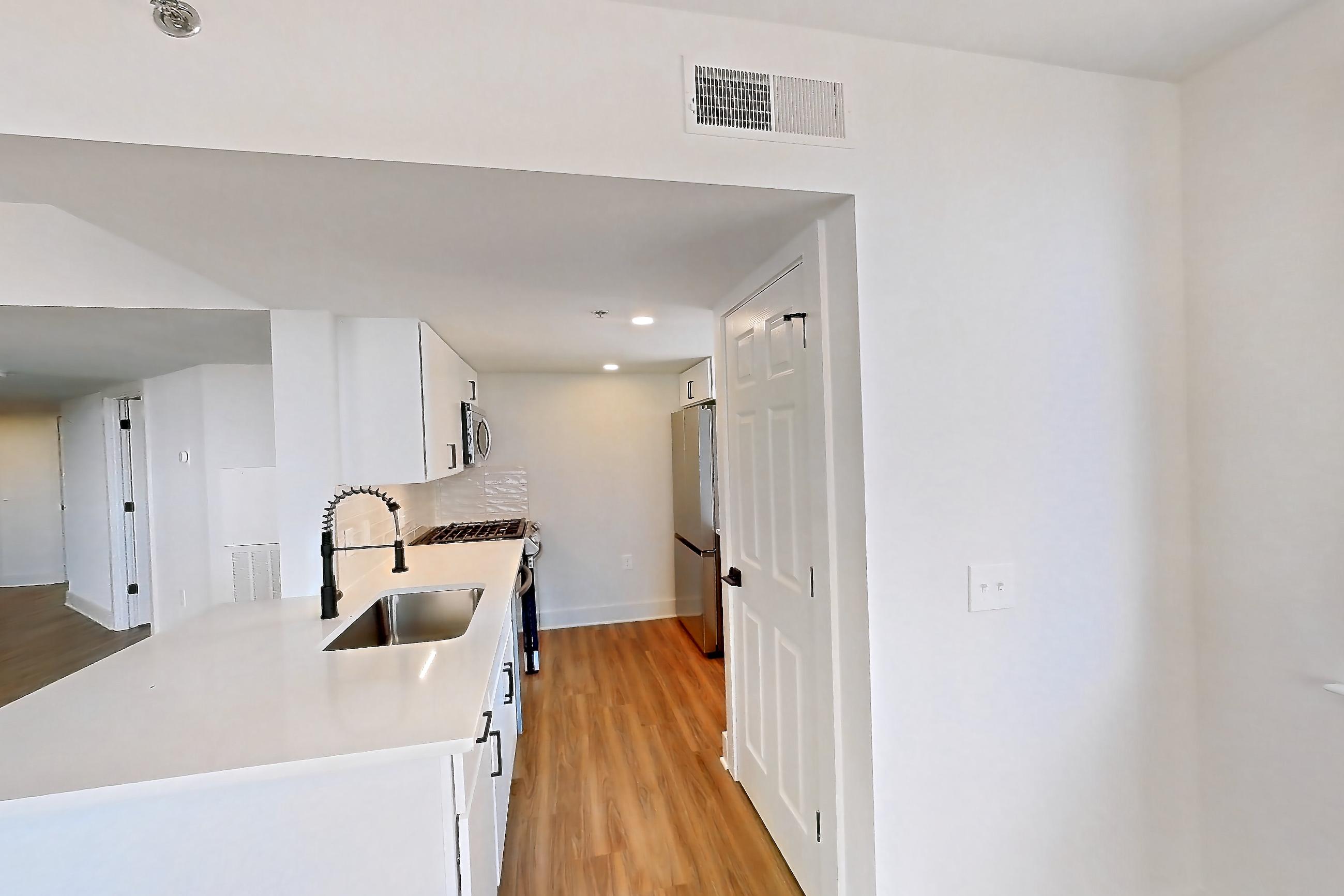 Dining area with gas range, light countertops, light wood-finish flooring, oven/range, refrigerator, and stainless steel appliances, Apartment 01-1001 at Cortland Pentagon City