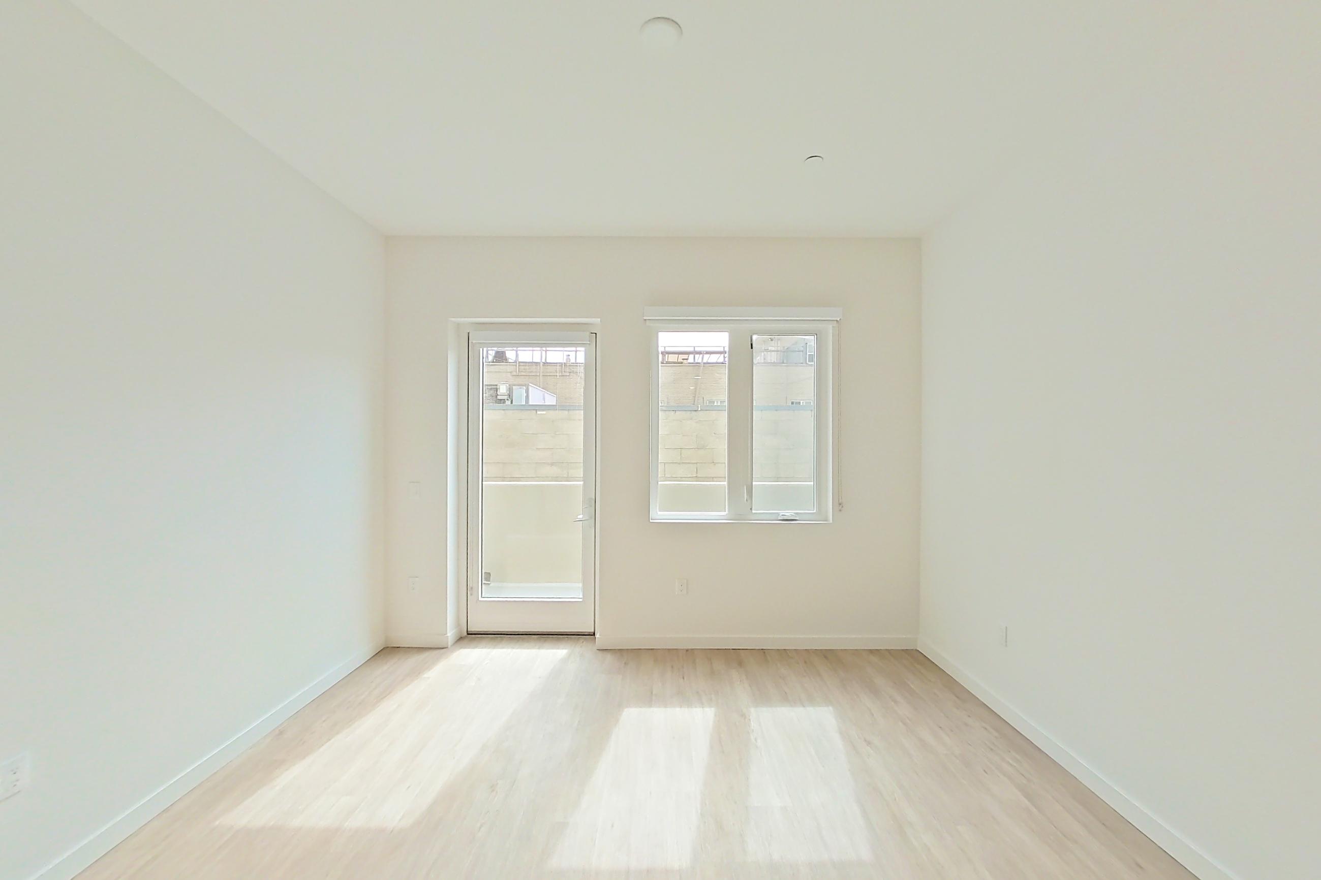 Living room with light wood-finish flooring, Apartment 320 at Denizen