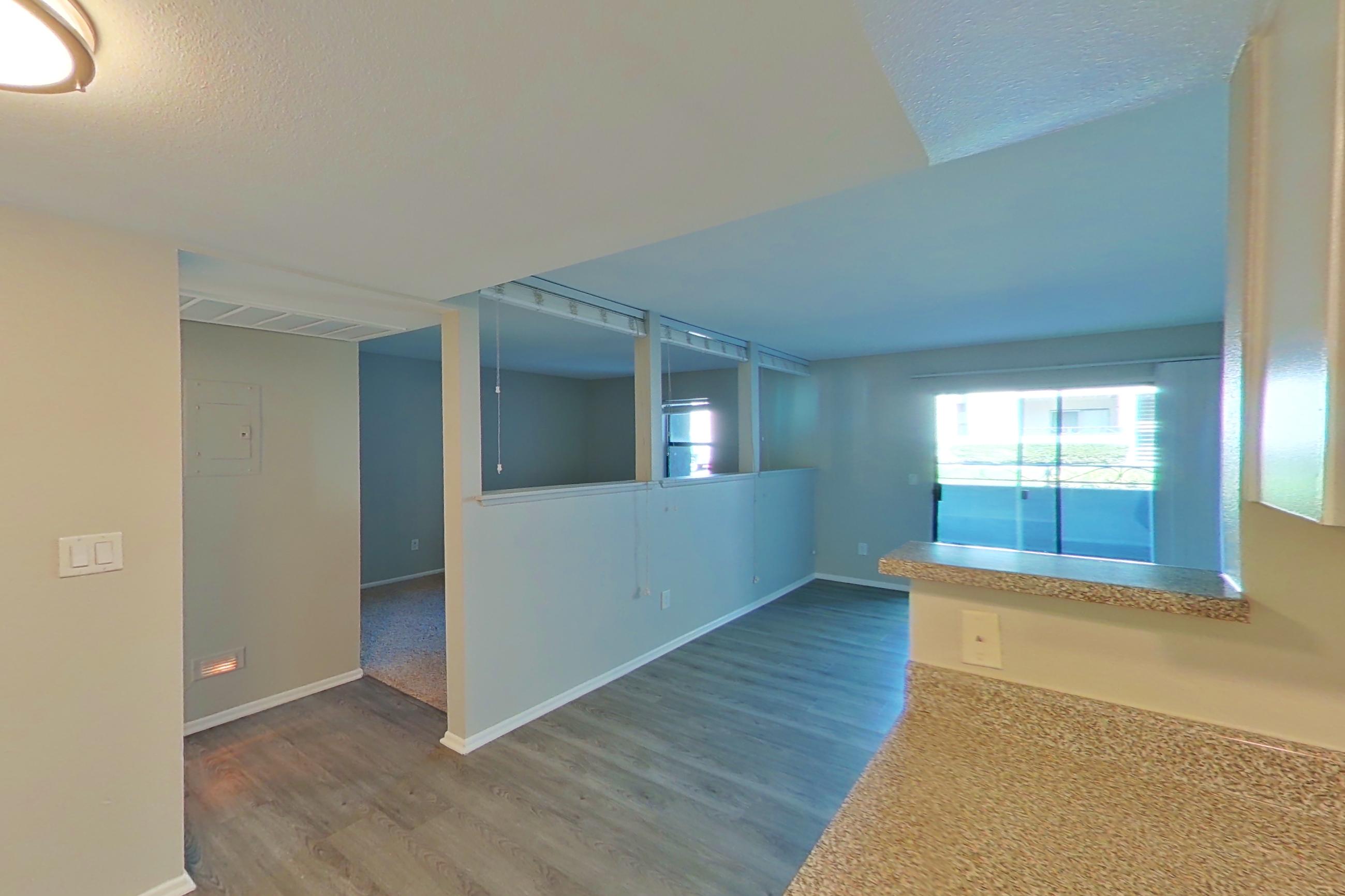 Kitchen with black appliances, dishwasher, electric range, light countertops, light wood-finish flooring, oven/range, and stainless steel appliances, Apartment 12 at Avana Rancho Cucamonga