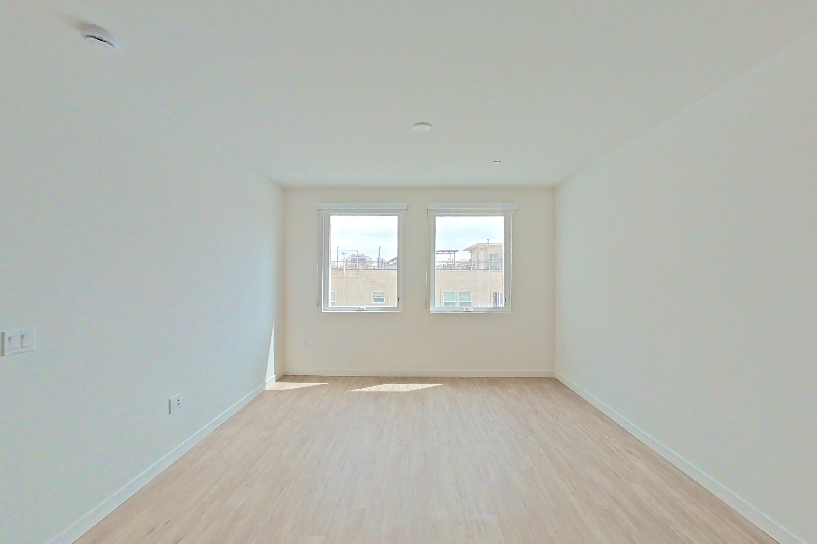 Living room with light wood-finish flooring, Apartment 420 at Denizen