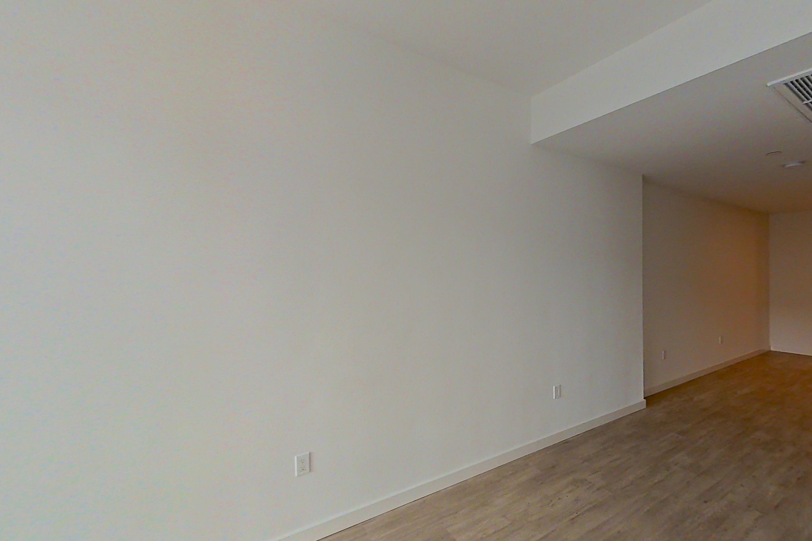 Living room with light wood-finish flooring, Apartment 306 at Denizen