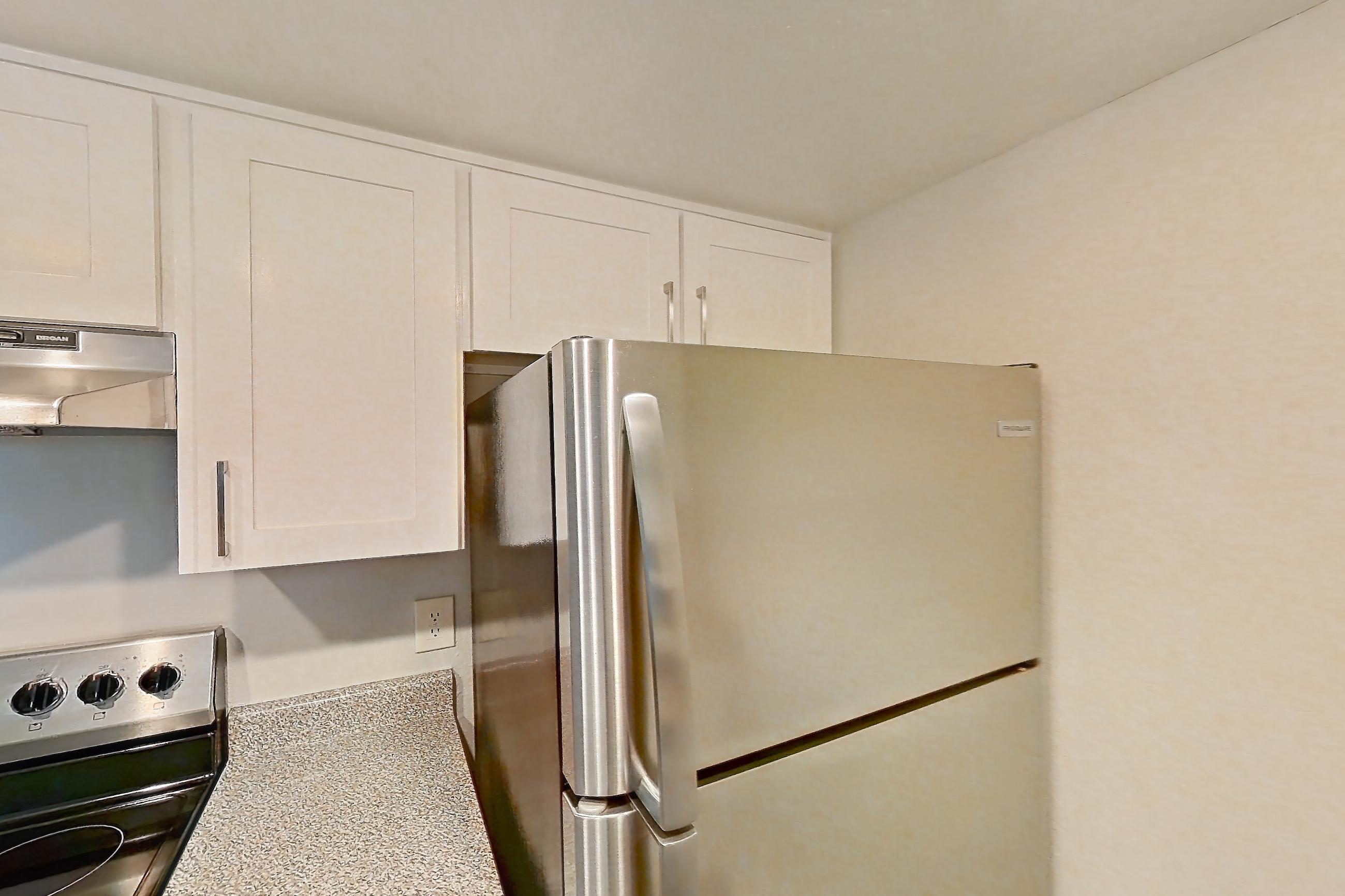 Kitchen with dishwasher, light stone countertops, light wood-finish flooring, microwave, refrigerator, and stainless steel appliances, Apartment 09 at Avana Rancho Cucamonga