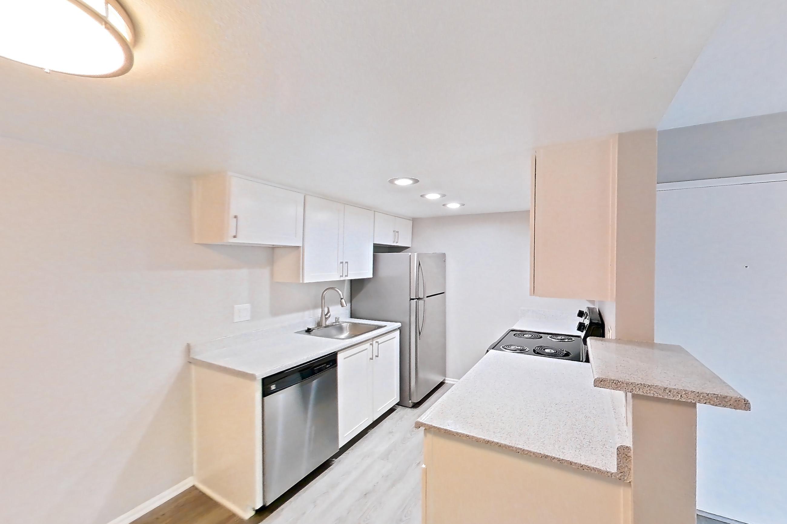 Dining room with dishwasher, electric range, light stone countertops, light wood-finish flooring, oven/range, refrigerator, stainless steel appliances, and white appliances, Apartment 06 at Avana Rancho Cucamonga