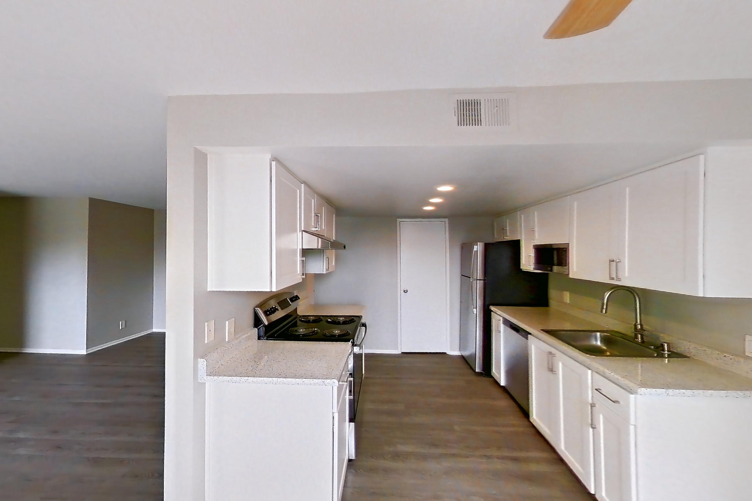 Dining room with dark wood-finish flooring, dishwasher, electric range, light stone countertops, light wood-finish flooring, oven/range, and stainless steel appliances, Apartment 11 at Avana Rancho Cucamonga