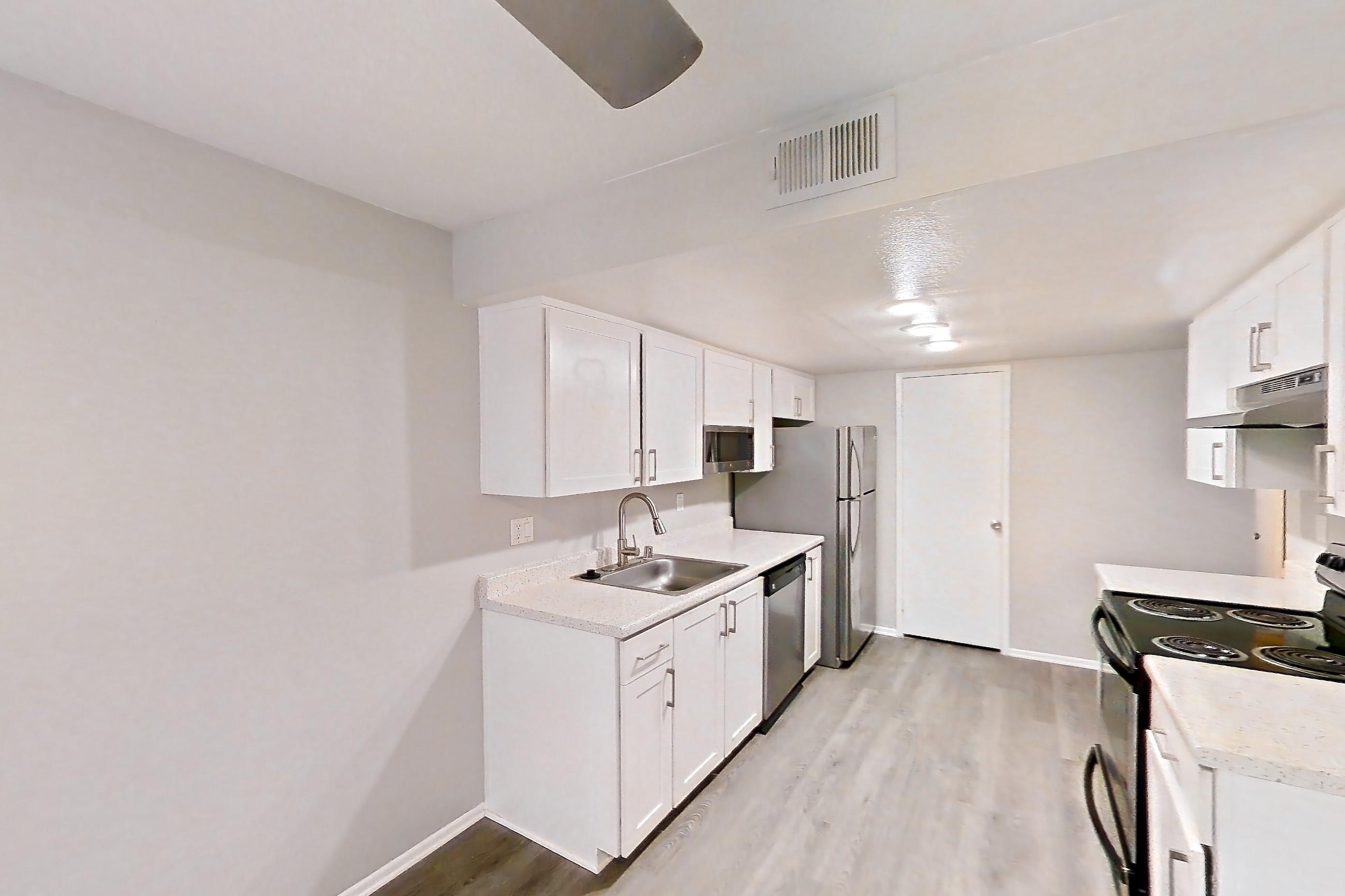 Dining room with dark wood-finish flooring, dishwasher, electric range, light countertops, light stone countertops, light wood-finish flooring, oven/range, refrigerator, and stainless steel appliances, Apartment 01 at Avana Rancho Cucamonga