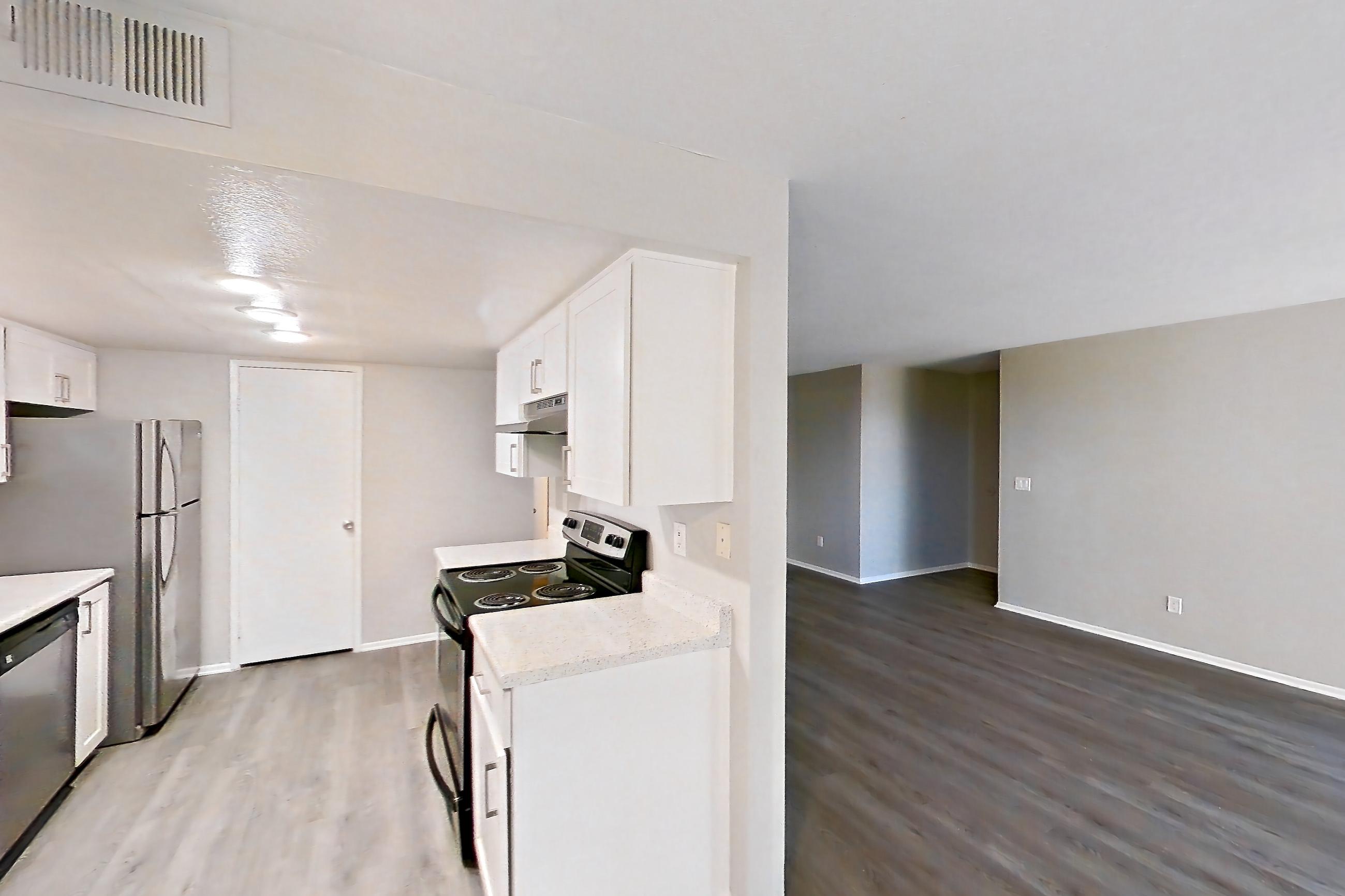 Dining room with dark wood-finish flooring, dishwasher, electric range, light countertops, light stone countertops, light wood-finish flooring, oven/range, refrigerator, and stainless steel appliances, Apartment 01 at Avana Rancho Cucamonga