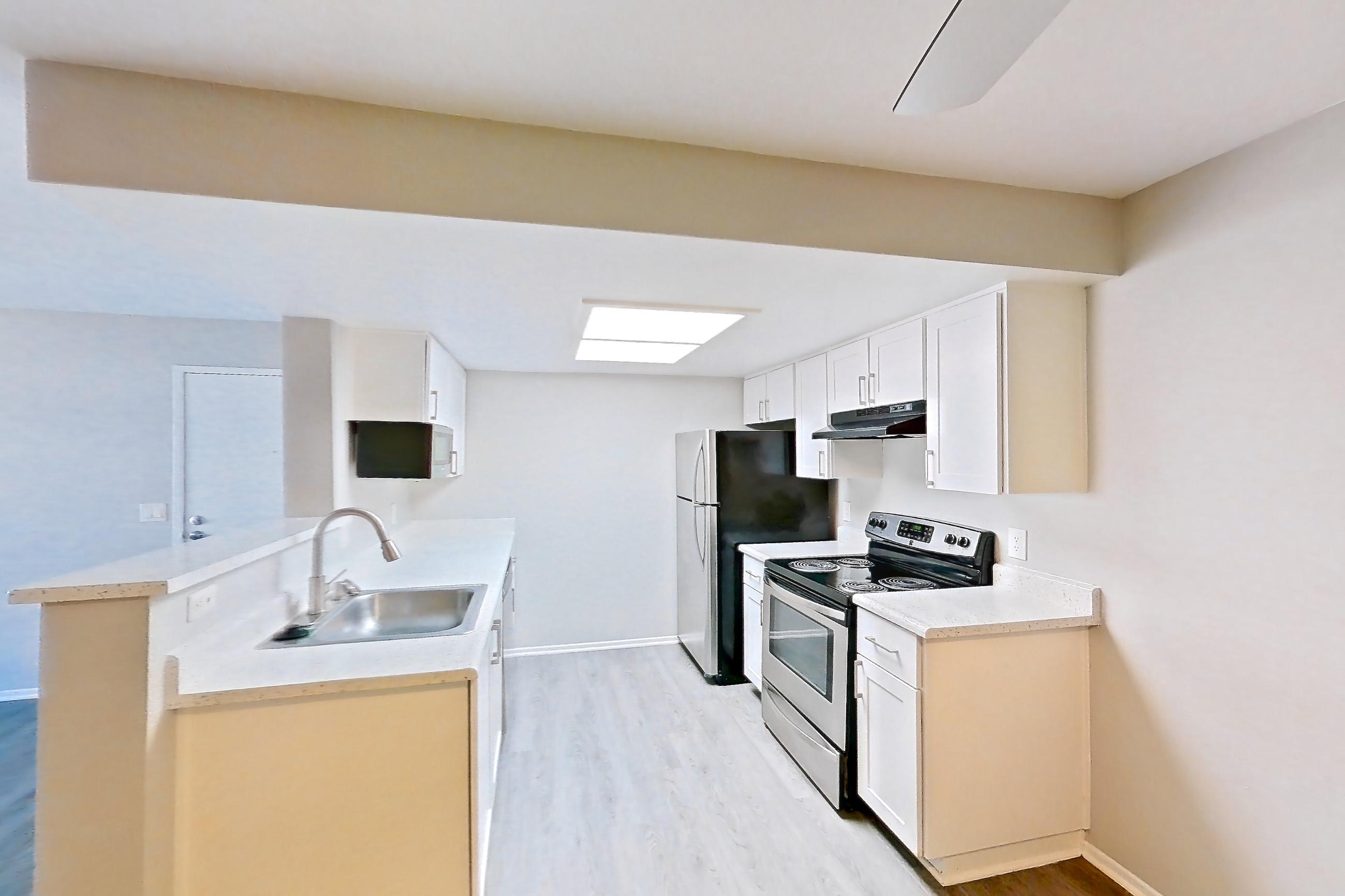 Dining room with dark wood-finish flooring, electric range, light countertops, light stone countertops, light wood-finish flooring, oven/range, refrigerator, and stainless steel appliances, Apartment 11 at Avana Rancho Cucamonga