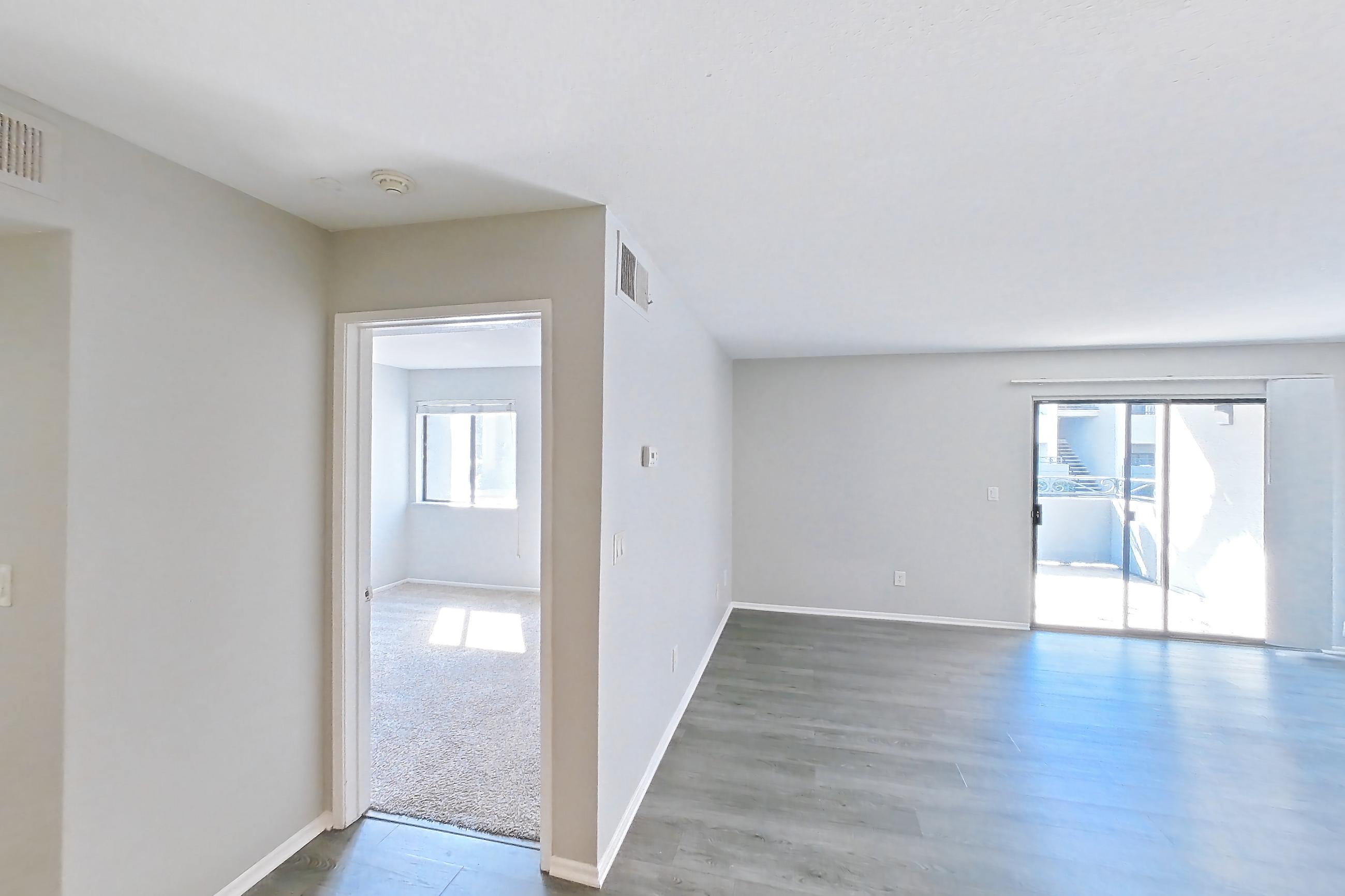 Dining room with dark carpet, dark wood-finish flooring, electric range, in-unit laundry, light countertops, light wood-finish flooring, oven/range, refrigerator, and stainless steel appliances, Apartment 14 at Avana Rancho Cucamonga