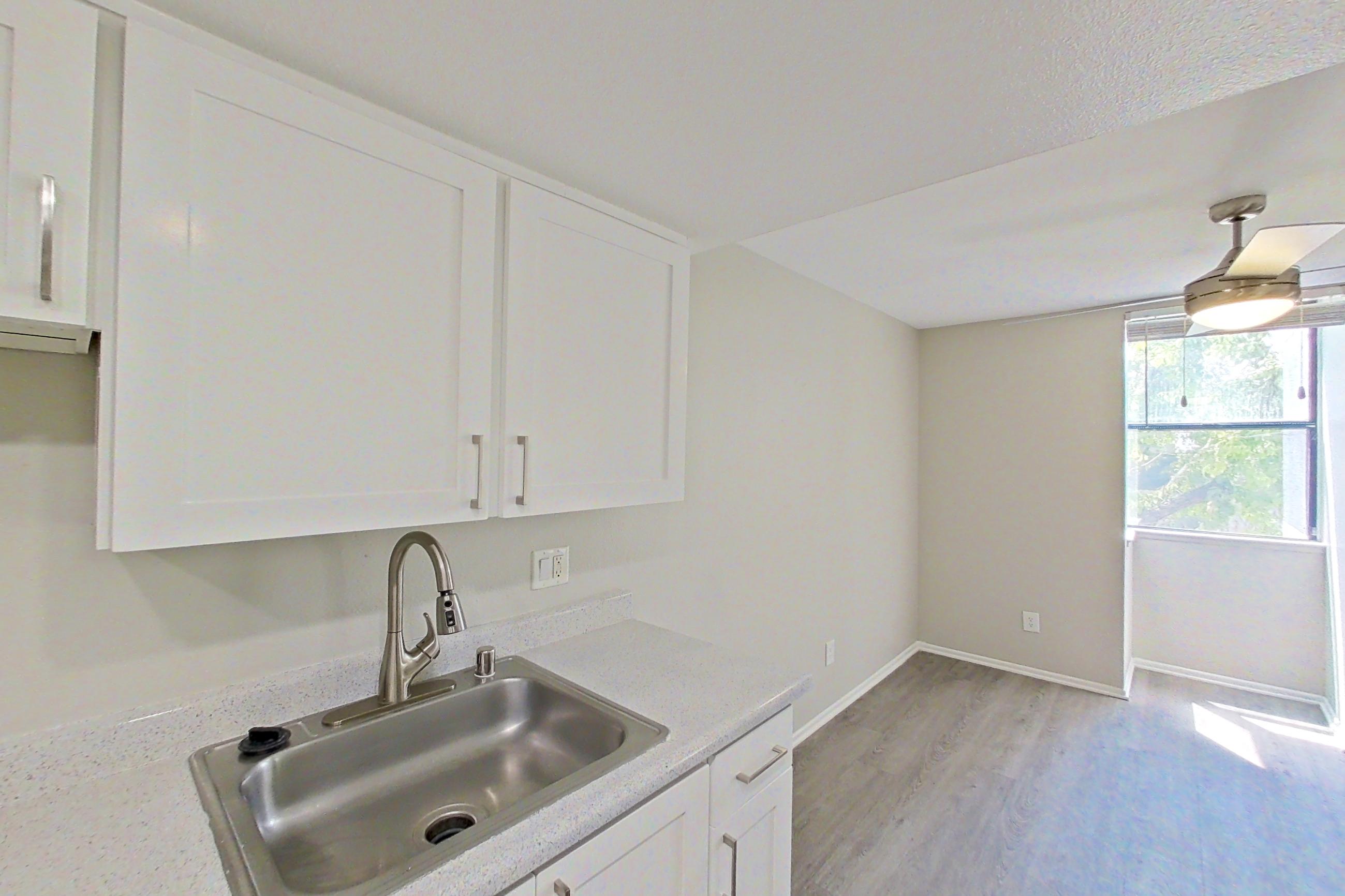 Kitchen with dishwasher, electric range, light countertops, light wood-finish flooring, microwave, oven/range, refrigerator, and stainless steel appliances, Apartment 07 at Avana Rancho Cucamonga