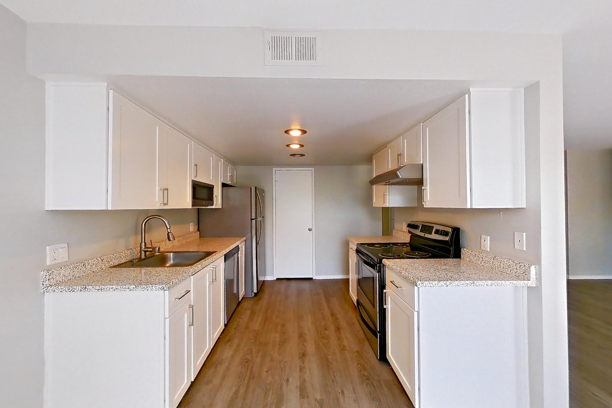 Dining space with dishwasher, electric range, light stone countertops, oven/range, range hood, refrigerator, and stainless steel appliances, Apartment 09 at Avana Rancho Cucamonga