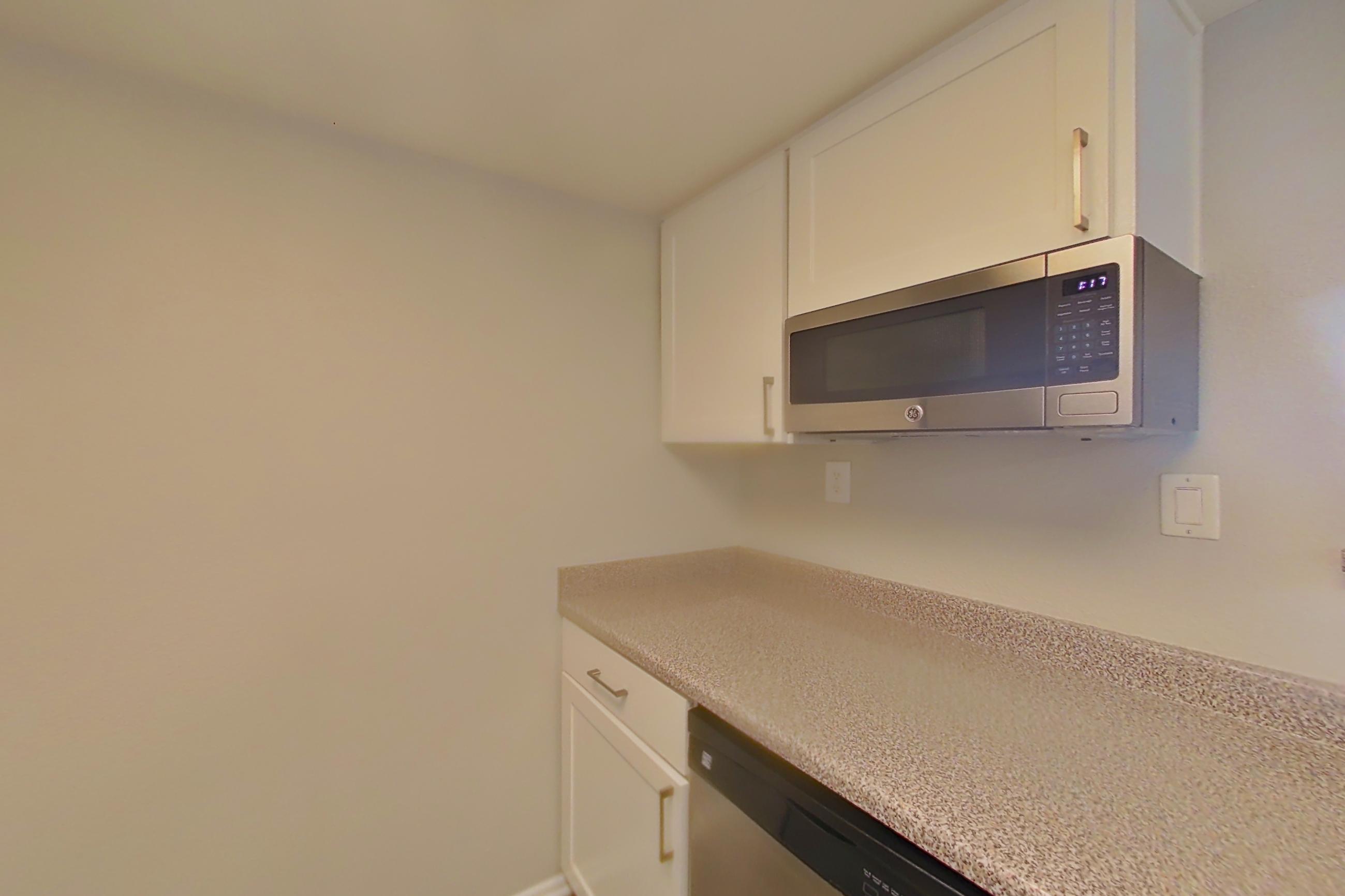 Kitchen with dishwasher, electric range, light countertops, light wood-finish flooring, oven/range, refrigerator, and stainless steel appliances, Apartment 08 at Avana Rancho Cucamonga