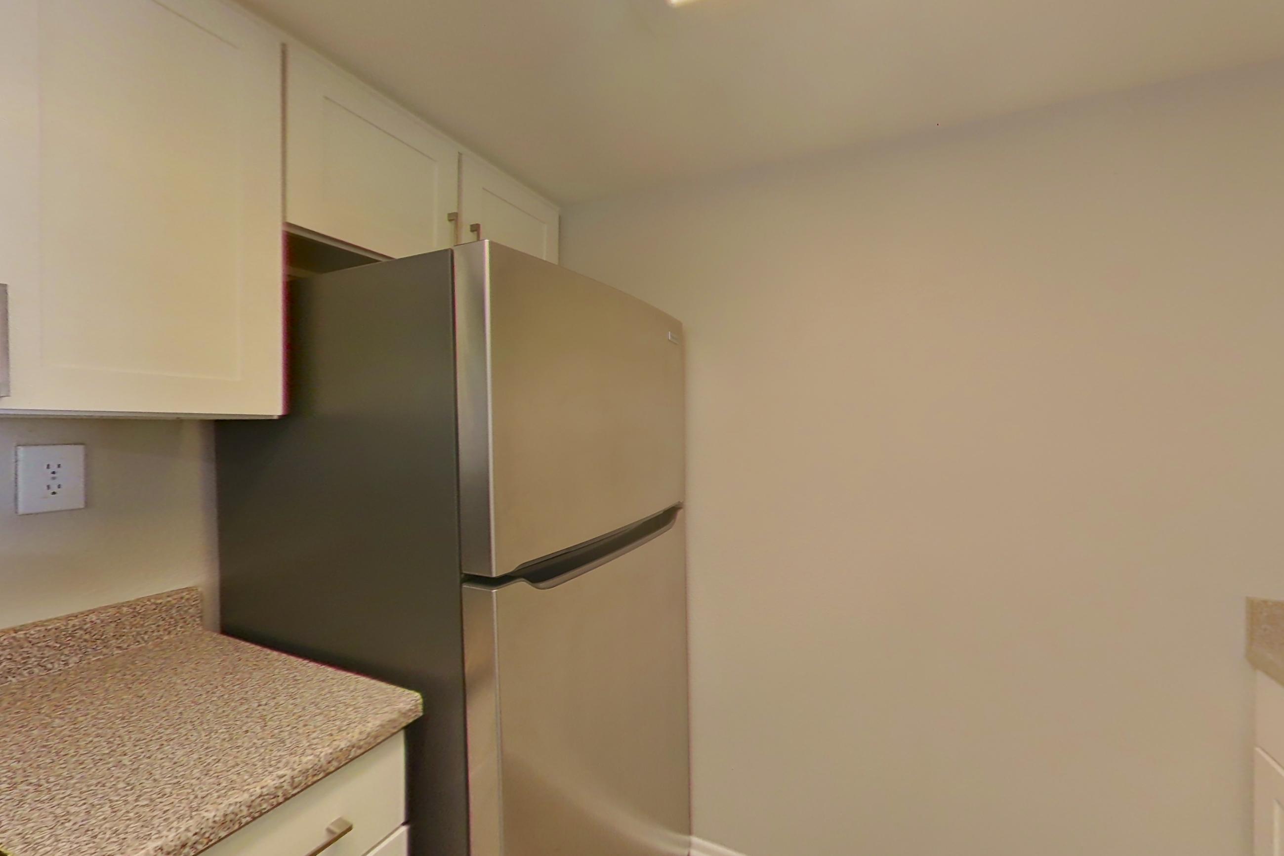 Kitchen with dishwasher, electric range, light countertops, light wood-finish flooring, oven/range, refrigerator, and stainless steel appliances, Apartment 08 at Avana Rancho Cucamonga
