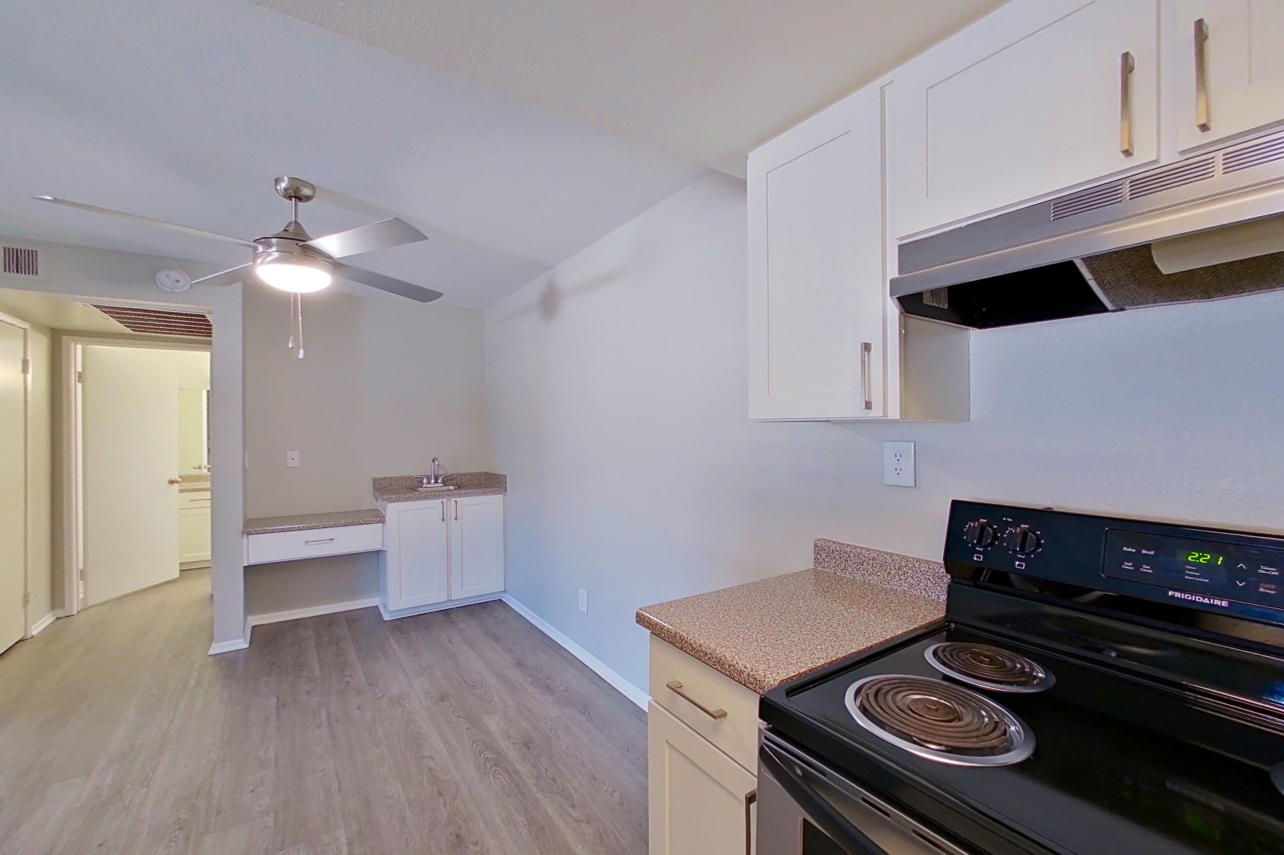 Kitchen with dishwasher, electric range, light countertops, light wood-finish flooring, oven/range, refrigerator, and stainless steel appliances, Apartment 08 at Avana Rancho Cucamonga