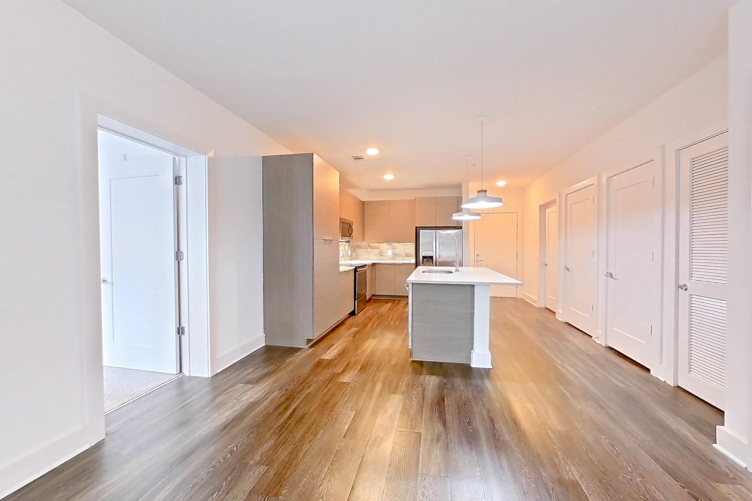 Living room with electric range, oven/range, and stainless steel appliances, Apartment 242 at Cortland at the Battery