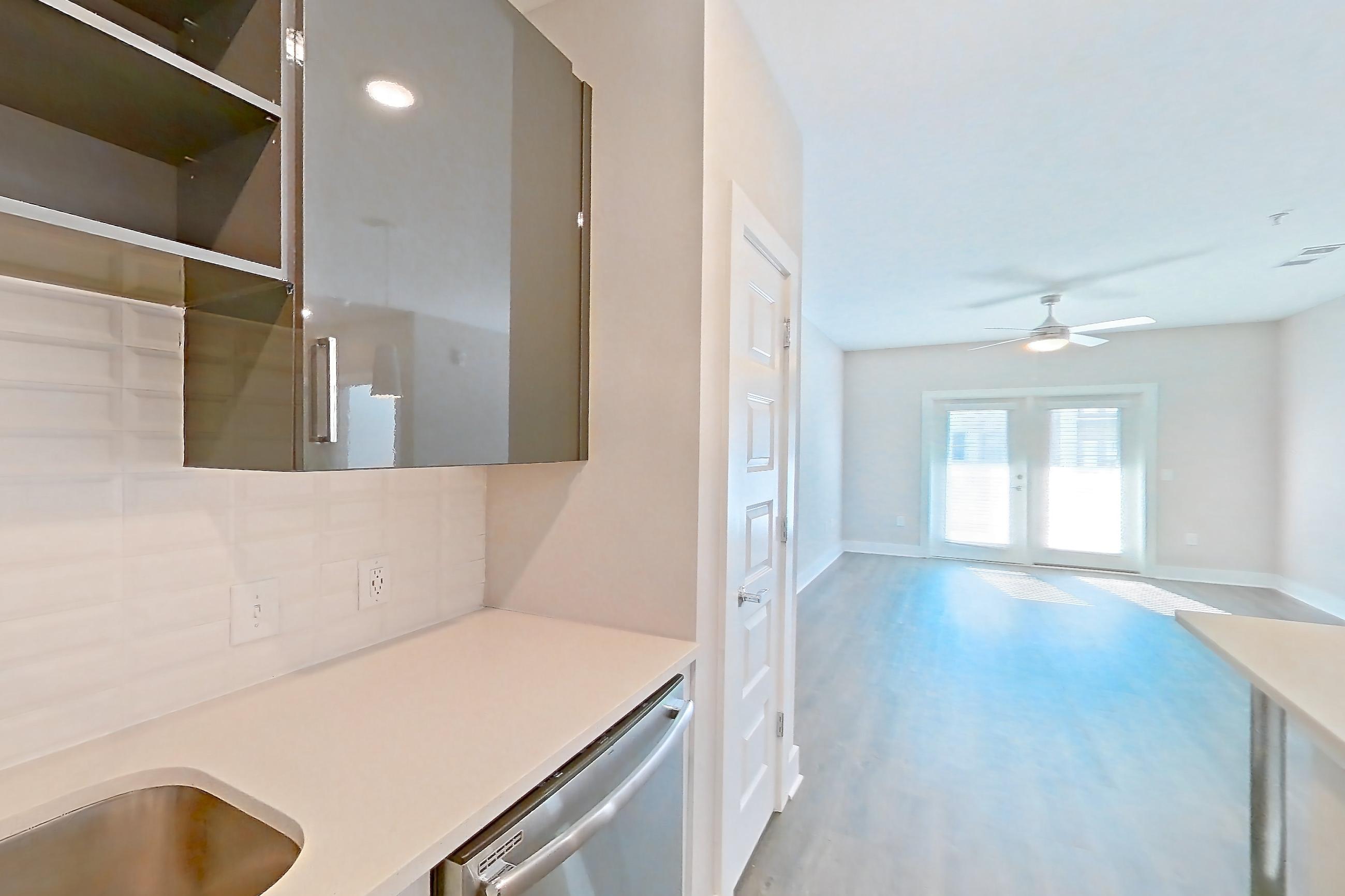 Kitchen with dark wood-finish flooring, dishwasher, electric range, light countertops, light wood-finish flooring, oven/range, refrigerator, and stainless steel appliances, Apartment 1466 at Cortland at the Hill
