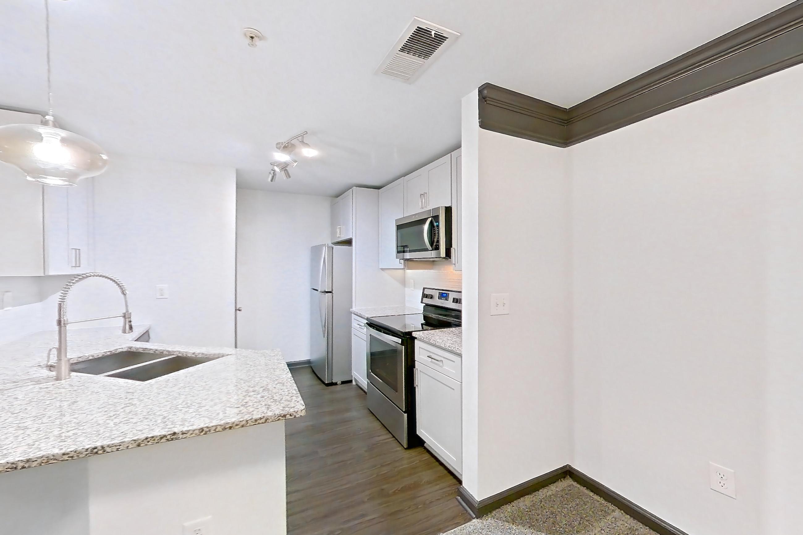 Dining room with dark carpet, electric range, kitchen island, light countertops, light stone countertops, oven/range, refrigerator, stainless steel appliances, and white appliances, Apartment 2524 at Cortland Duluth