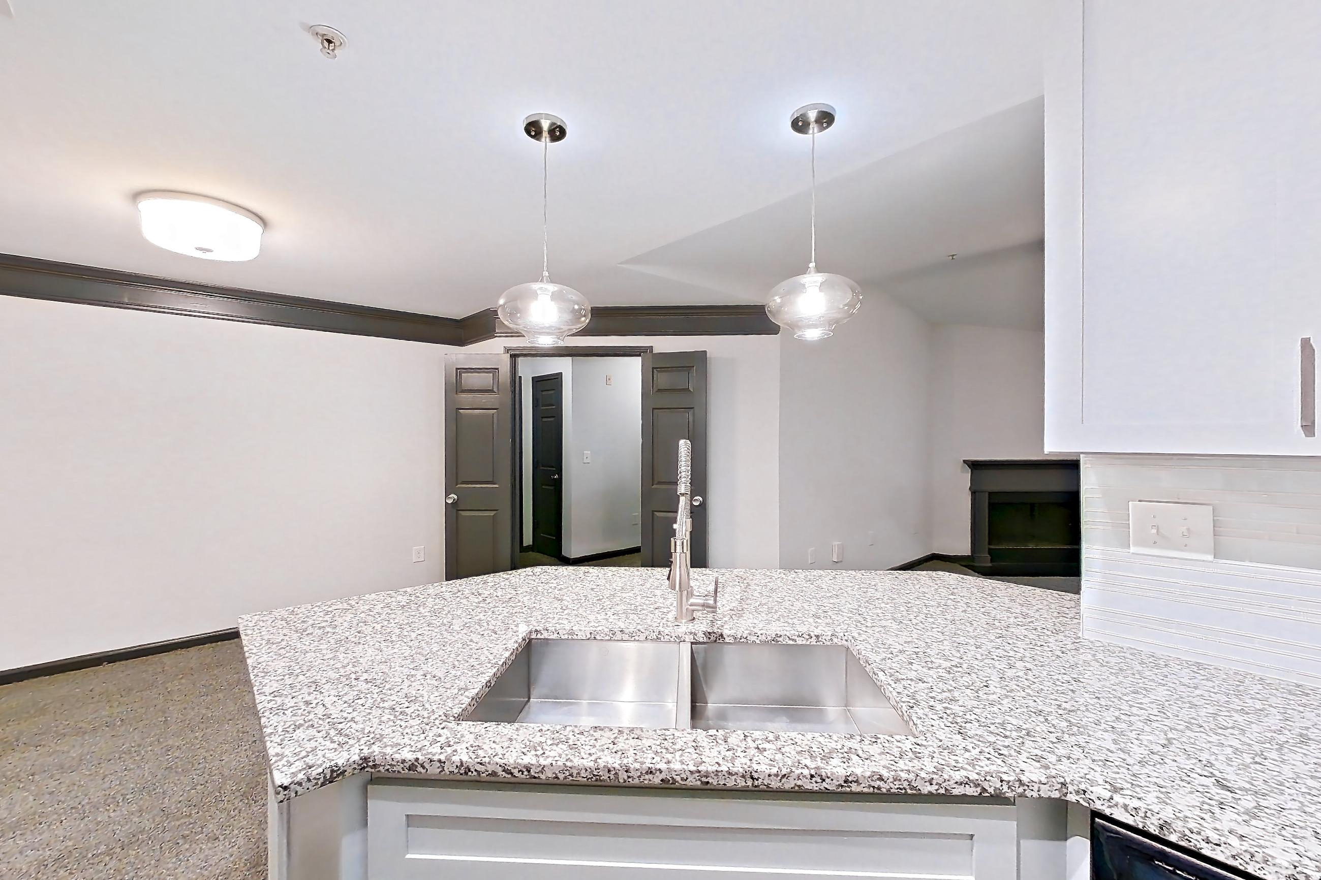 Kitchen with dark wood-finish flooring, dishwasher, electric range, light countertops, light stone countertops, microwave, oven/range, and stainless steel appliances, Apartment 2524 at Cortland Duluth