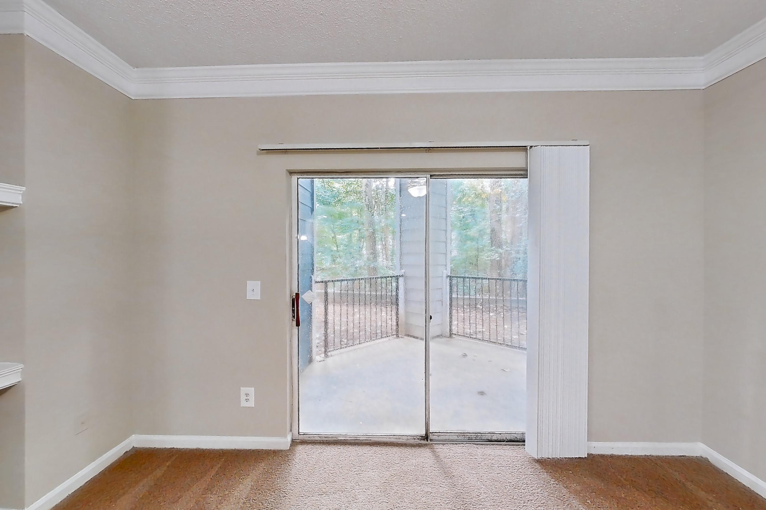 Living room with in-unit laundry and light carpet, Apartment 0230 at Cortland Duluth