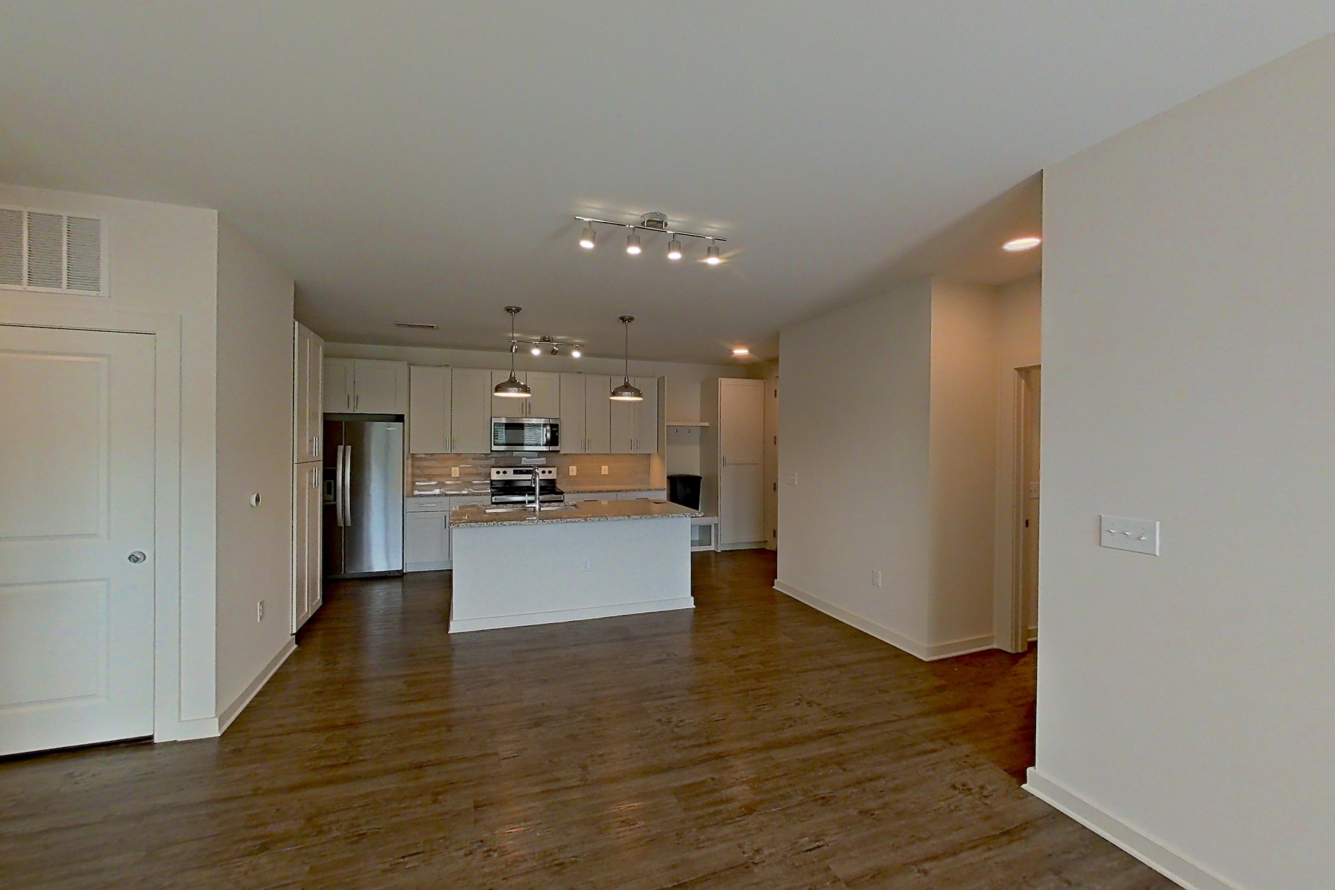Living space with dark wood-finish flooring, electric range, oven/range, refrigerator, and stainless steel appliances, Apartment 3-209 at Cortland Wren Northlake