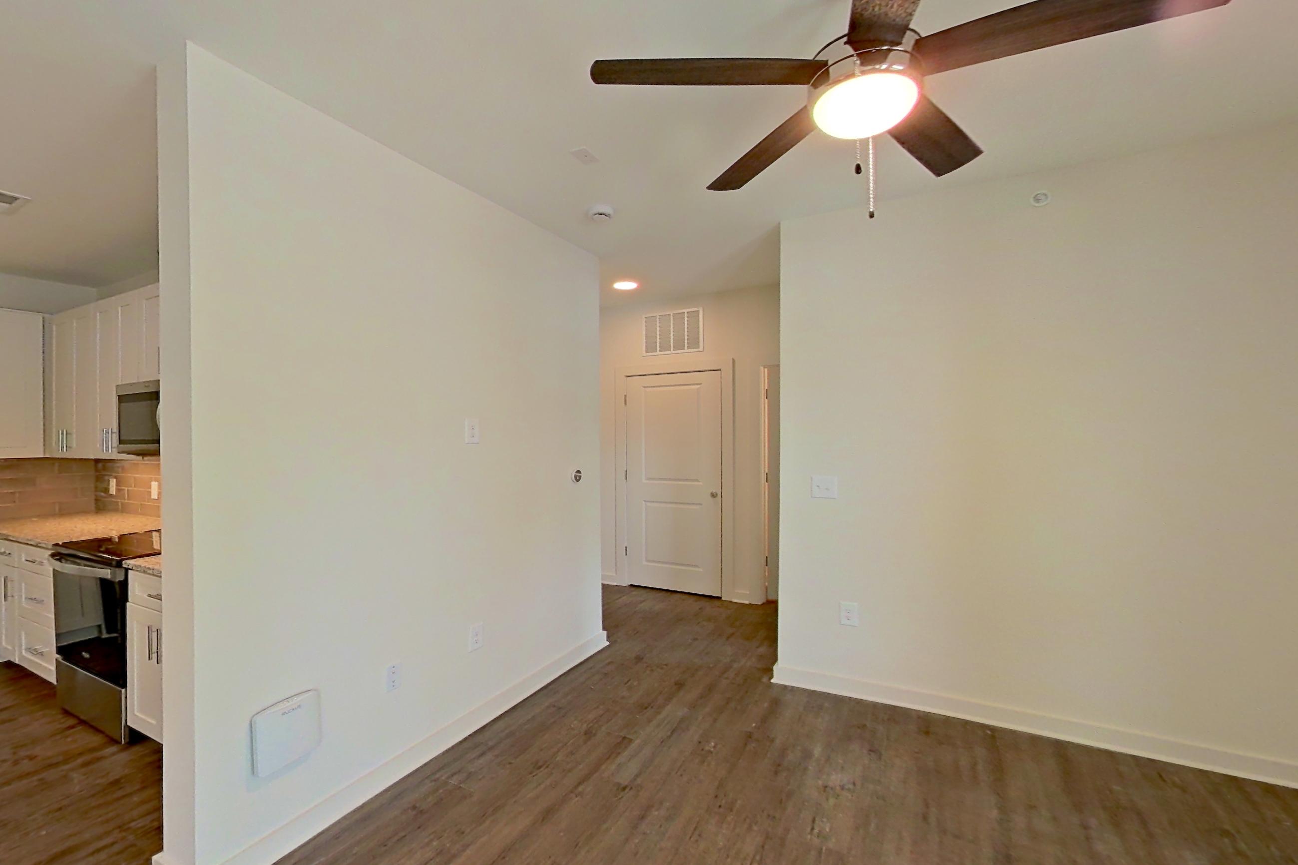 Living room with dark wood-finish flooring, Apartment 4-102 at Cortland Wren Northlake