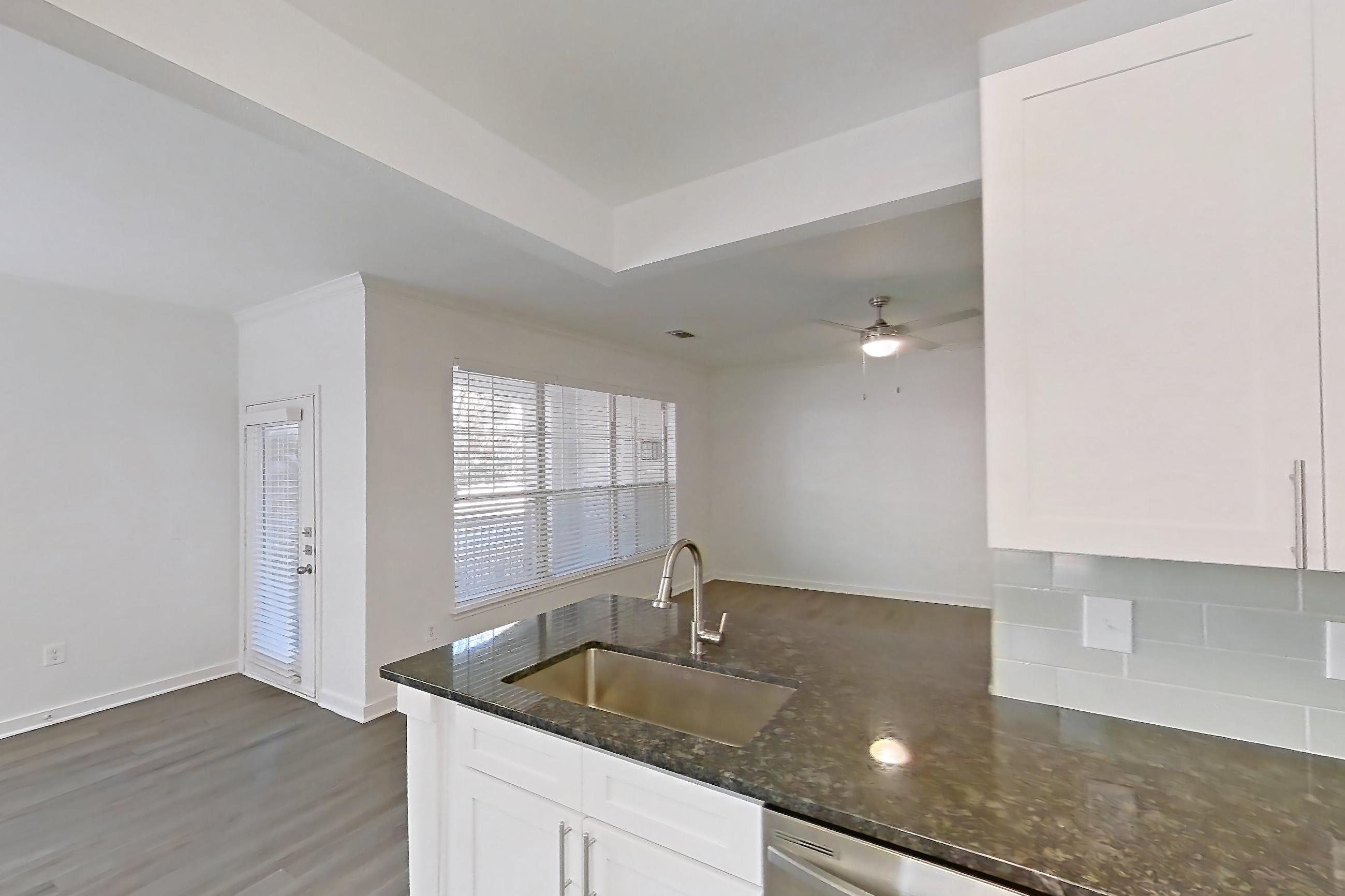 Kitchen with dark stone countertops, dark wood-finish flooring, dishwasher, electric range, oven/range, and stainless steel appliances, Apartment 01914 at Cortland West Plano