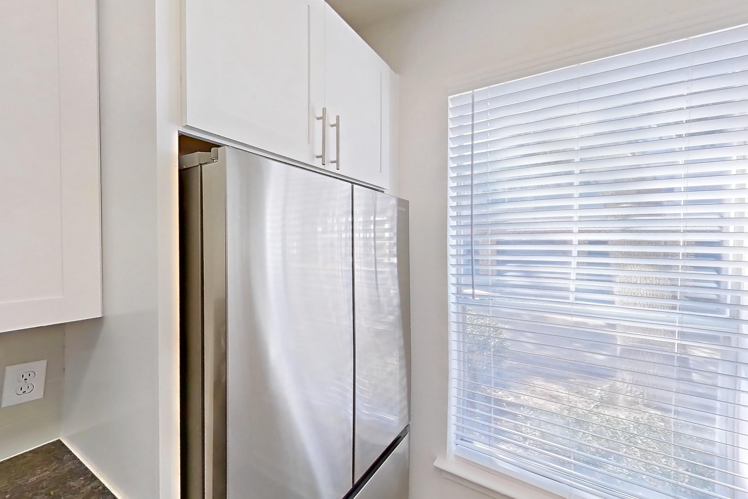 Kitchen with dark stone countertops, dark wood-finish flooring, dishwasher, electric range, oven/range, and stainless steel appliances, Apartment 01914 at Cortland West Plano