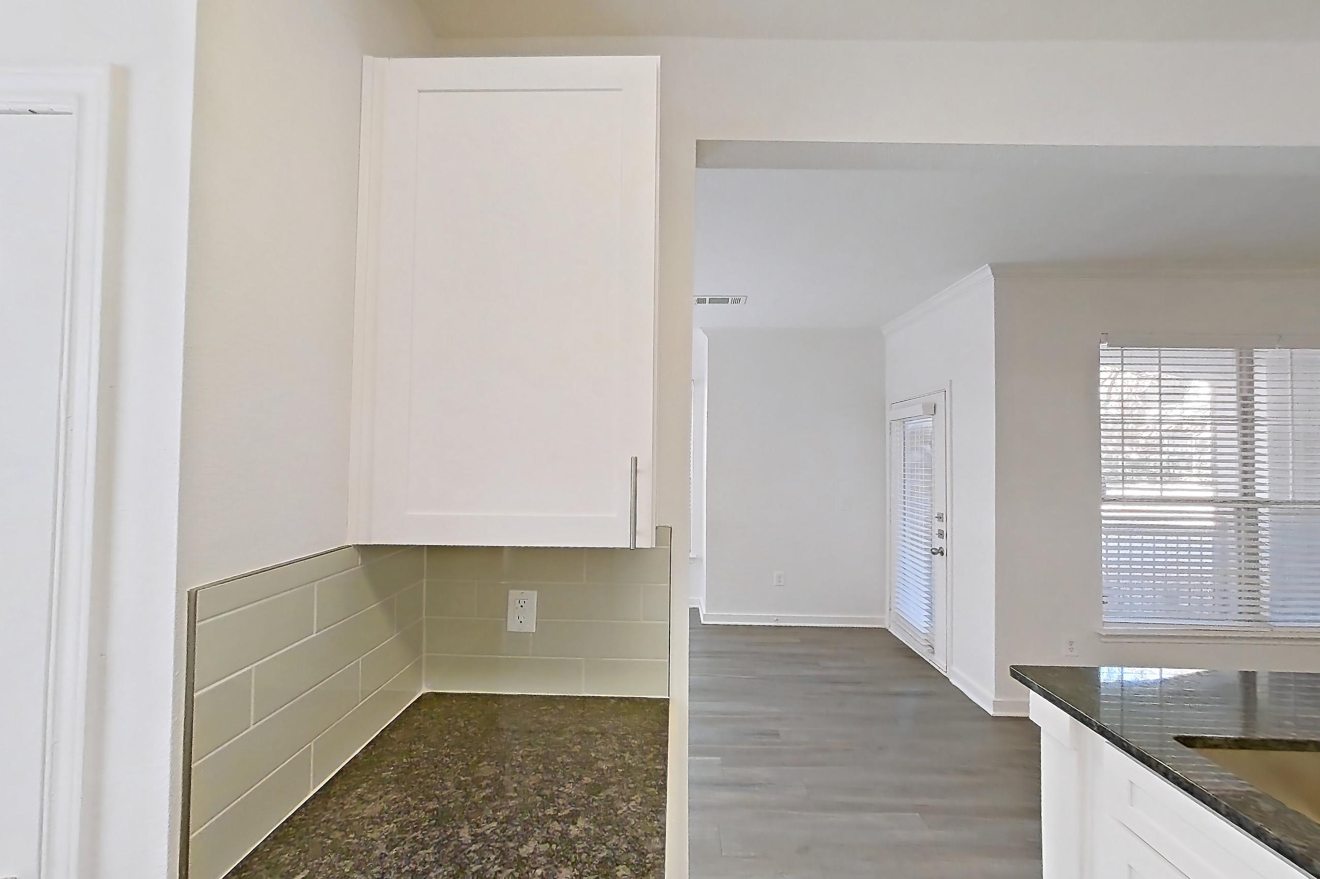 Kitchen with dark stone countertops, dark wood-finish flooring, dishwasher, electric range, oven/range, and stainless steel appliances, Apartment 01914 at Cortland West Plano