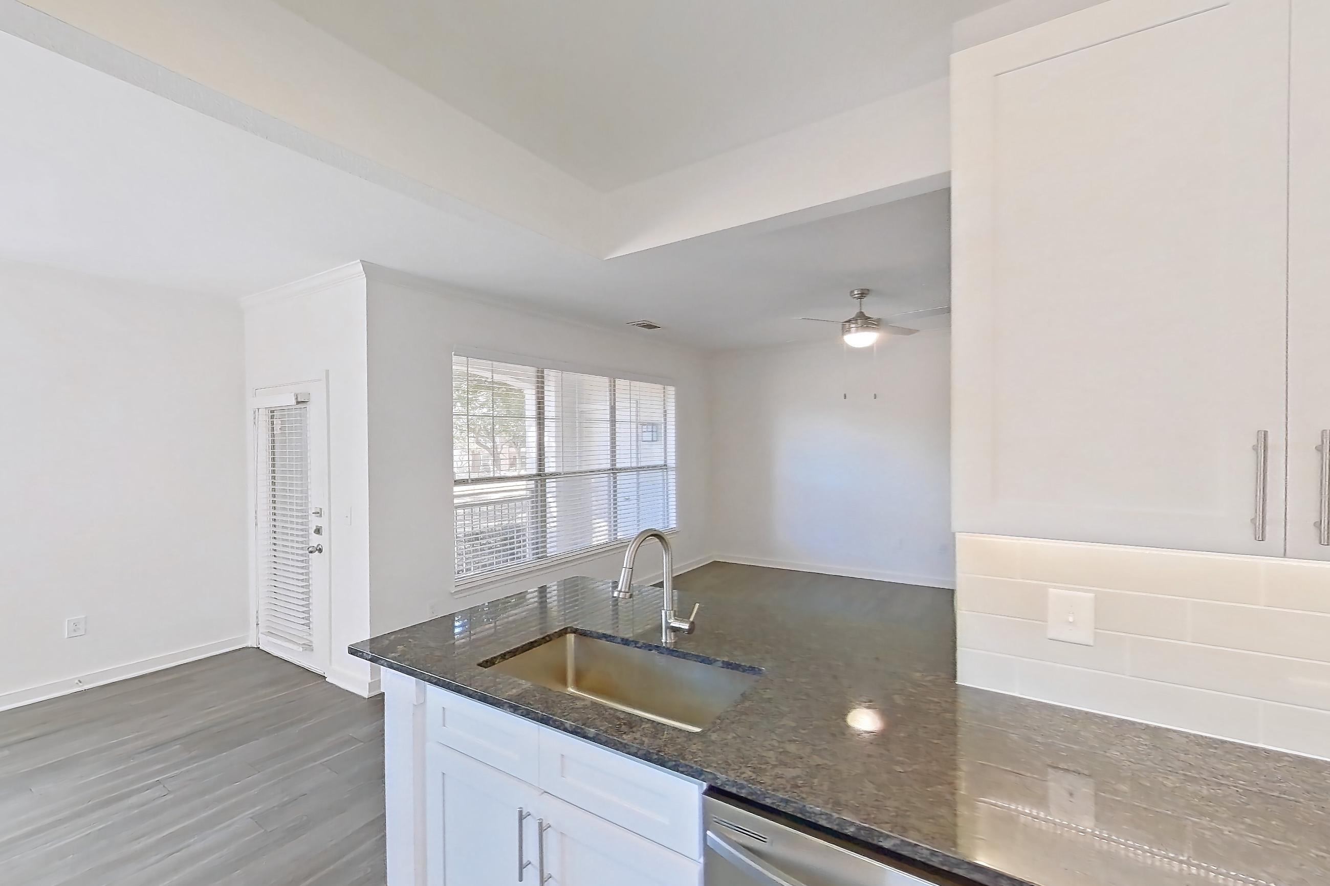 Kitchen with dark stone countertops, dark wood-finish flooring, dishwasher, electric range, oven/range, refrigerator, and stainless steel appliances, Apartment 02714 at Cortland West Plano