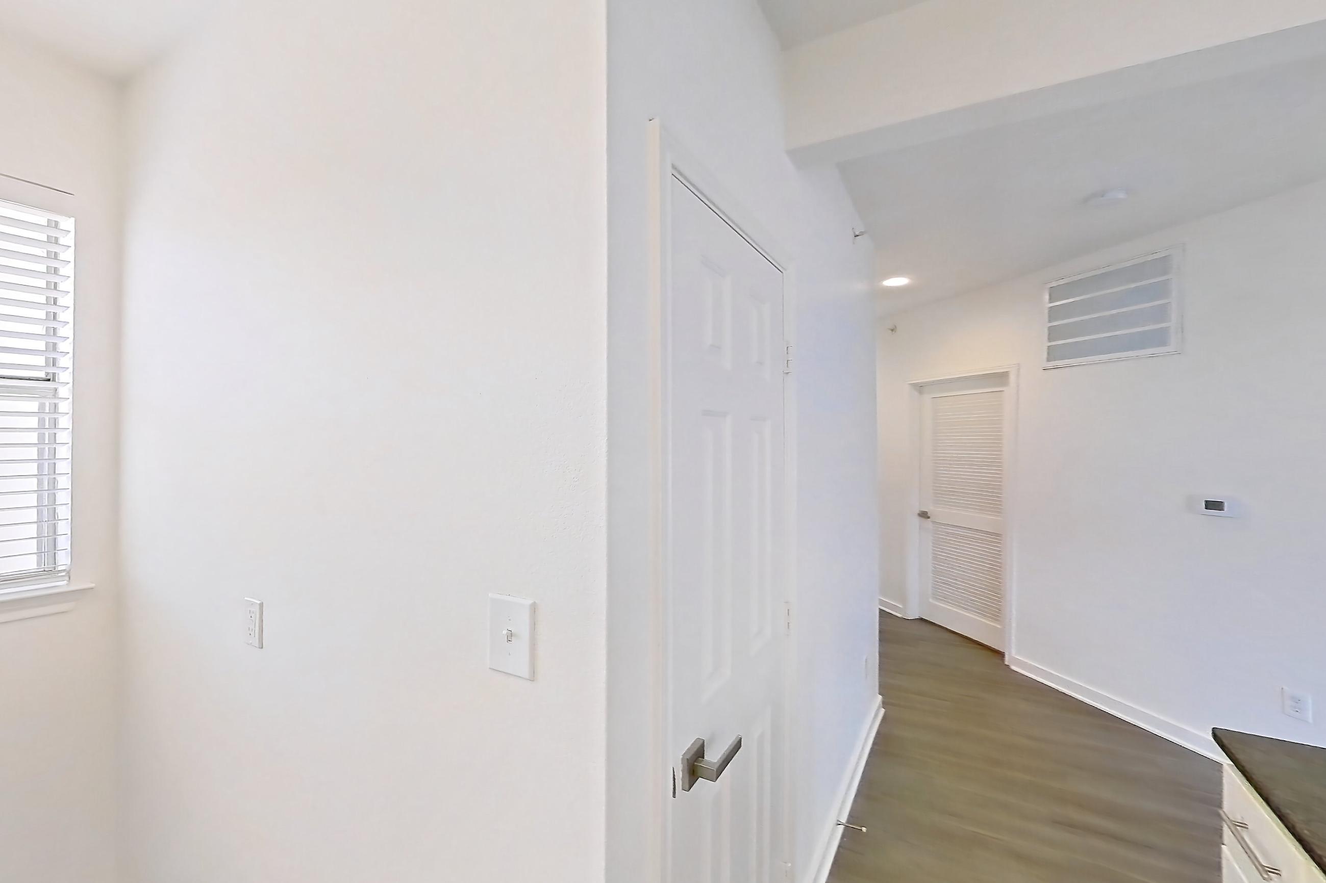 Kitchen with dark stone countertops, dark wood-finish flooring, dishwasher, electric range, light countertops, microwave, oven/range, and stainless steel appliances, Apartment 02831 at Cortland West Plano