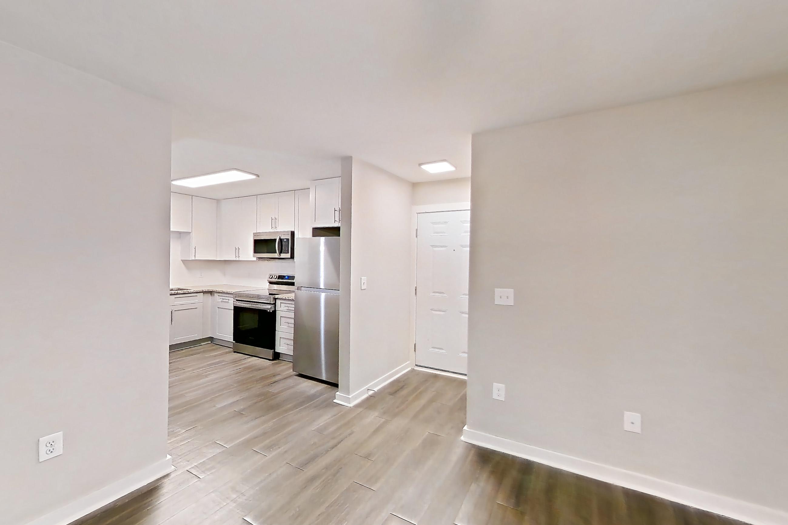 Living room with electric range, oven/range, refrigerator, and stainless steel appliances, Apartment 2141O at Cortland at the Village