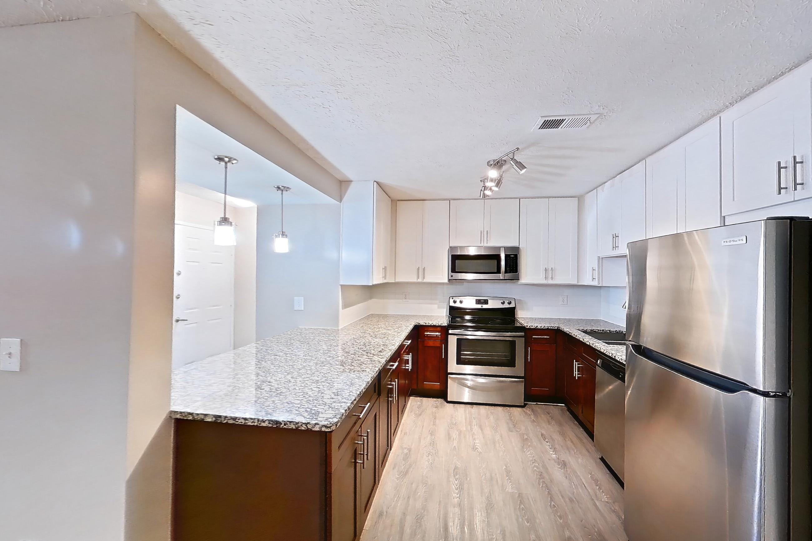 Dining room with dark wood-finish flooring, electric range, light stone countertops, oven/range, and stainless steel appliances, Apartment 2161D at Cortland at the Village