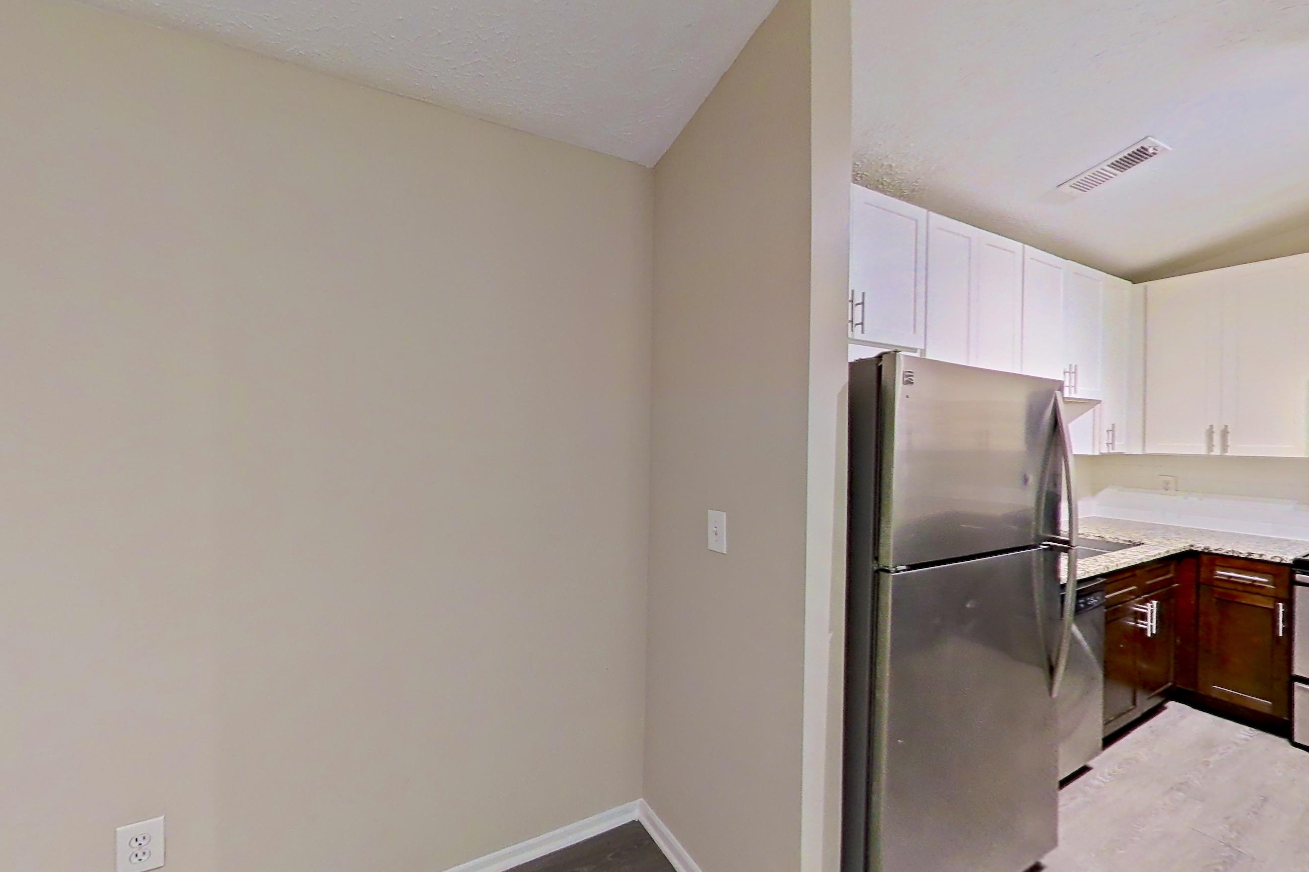 Dining room with dishwasher, electric range, light countertops, light stone countertops, light wood-finish flooring, oven/range, refrigerator, and stainless steel appliances, Apartment 2165S at Cortland at the Village