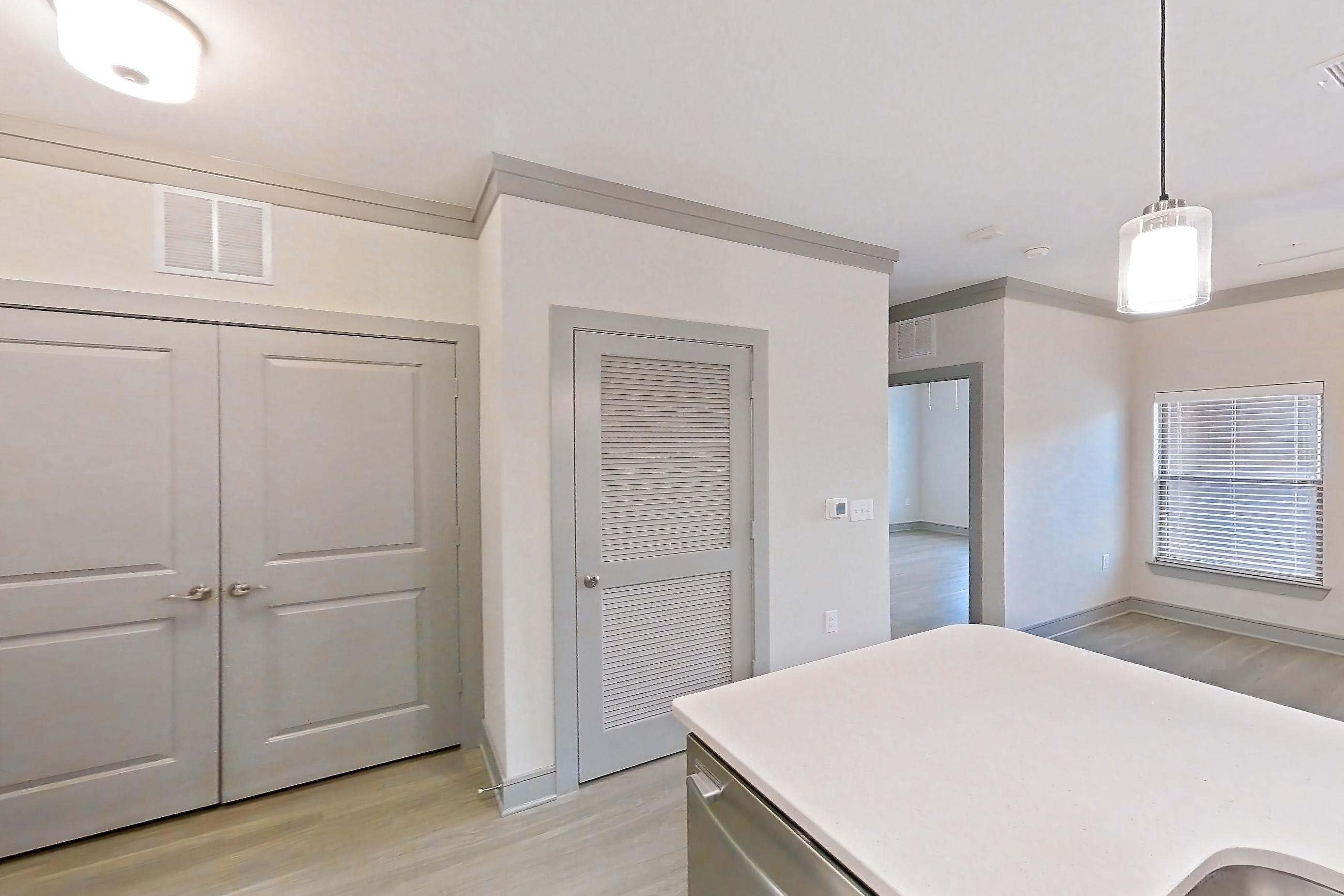 Kitchen with dishwasher, light stone countertops, light wood-finish flooring, oven/range, refrigerator, and stainless steel appliances, Apartment 18132 at Cortland Phillips Creek Ranch