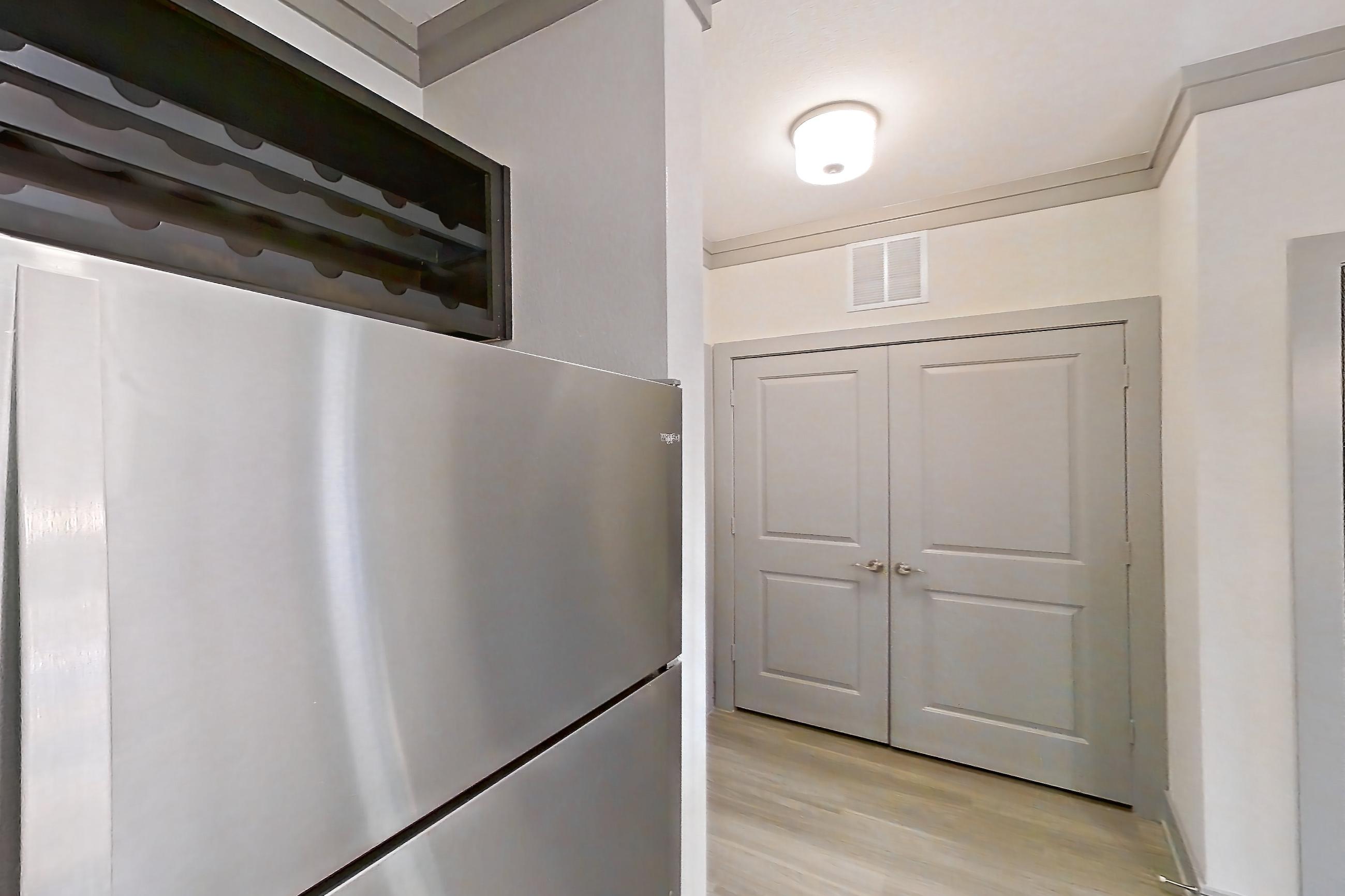 Kitchen with dishwasher, light stone countertops, light wood-finish flooring, oven/range, refrigerator, and stainless steel appliances, Apartment 18132 at Cortland Phillips Creek Ranch