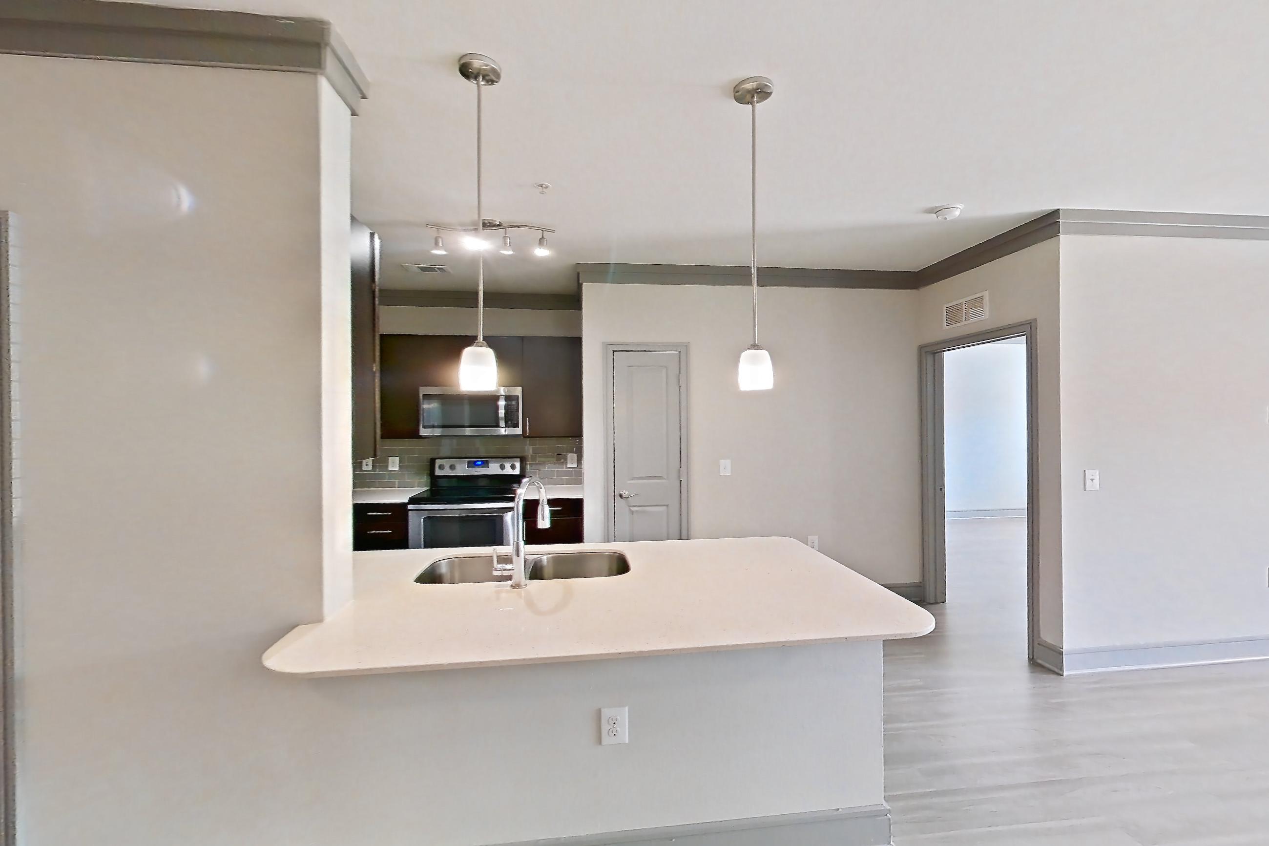 Dining room with electric range, light stone countertops, light wood-finish flooring, oven/range, and stainless steel appliances, Apartment 3104 at Cortland Phillips Creek Ranch